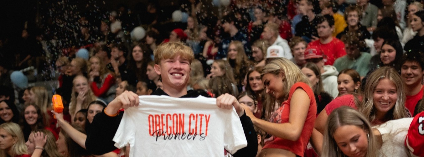 kids in pep rally holding up oregon city shirts
