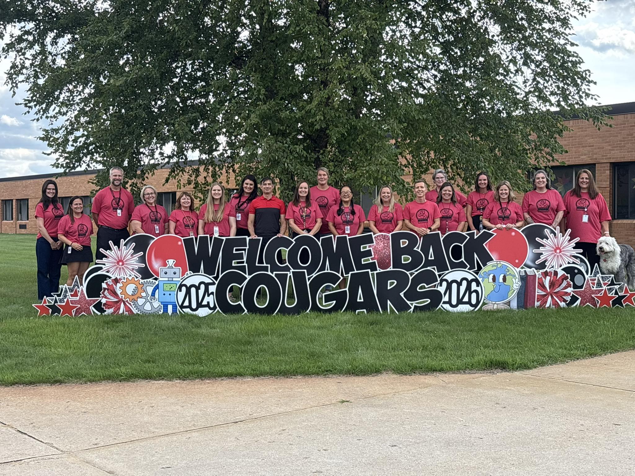 Courtade Elementary staff pictured with a sign that says "Welcome Back Cougars"