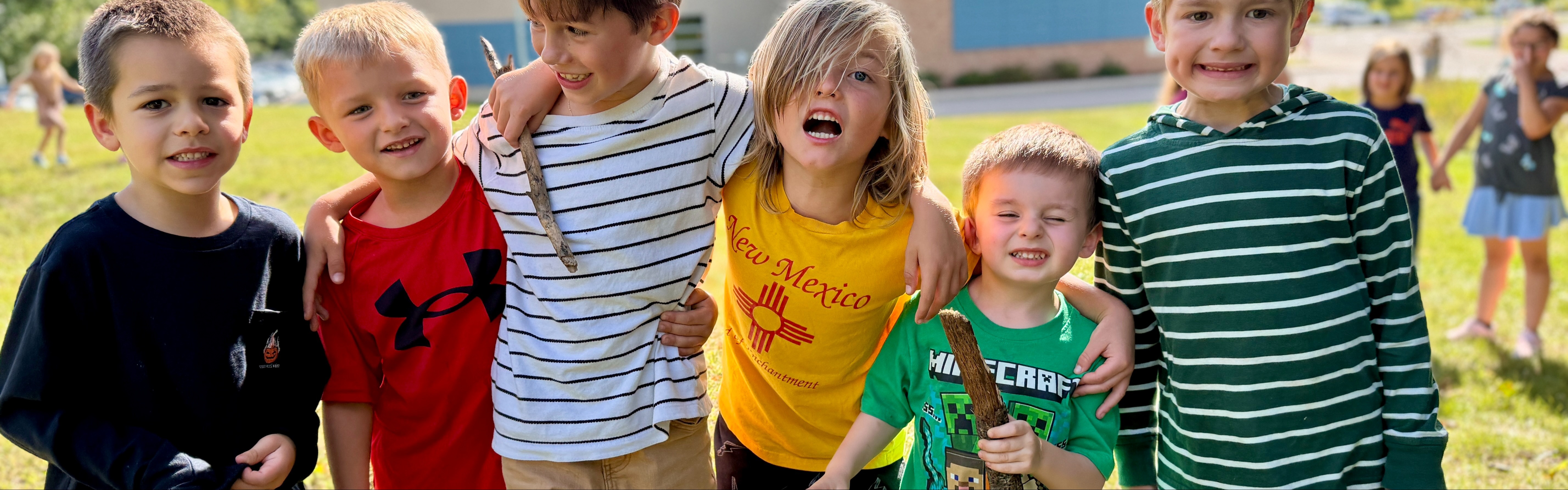 Eastern students smiling, standing arm in arm outside at recess