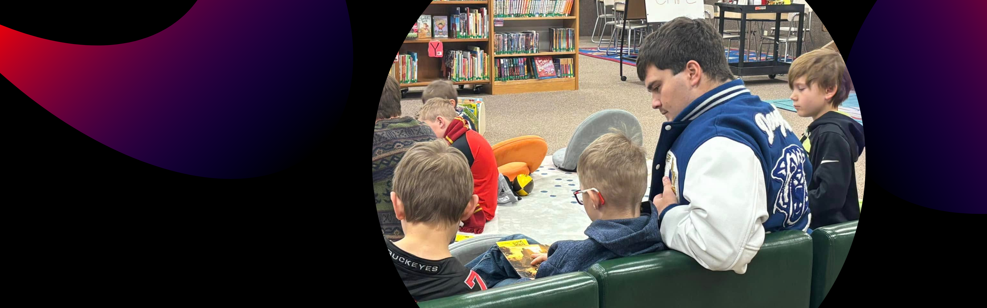high school student reading with elementary students