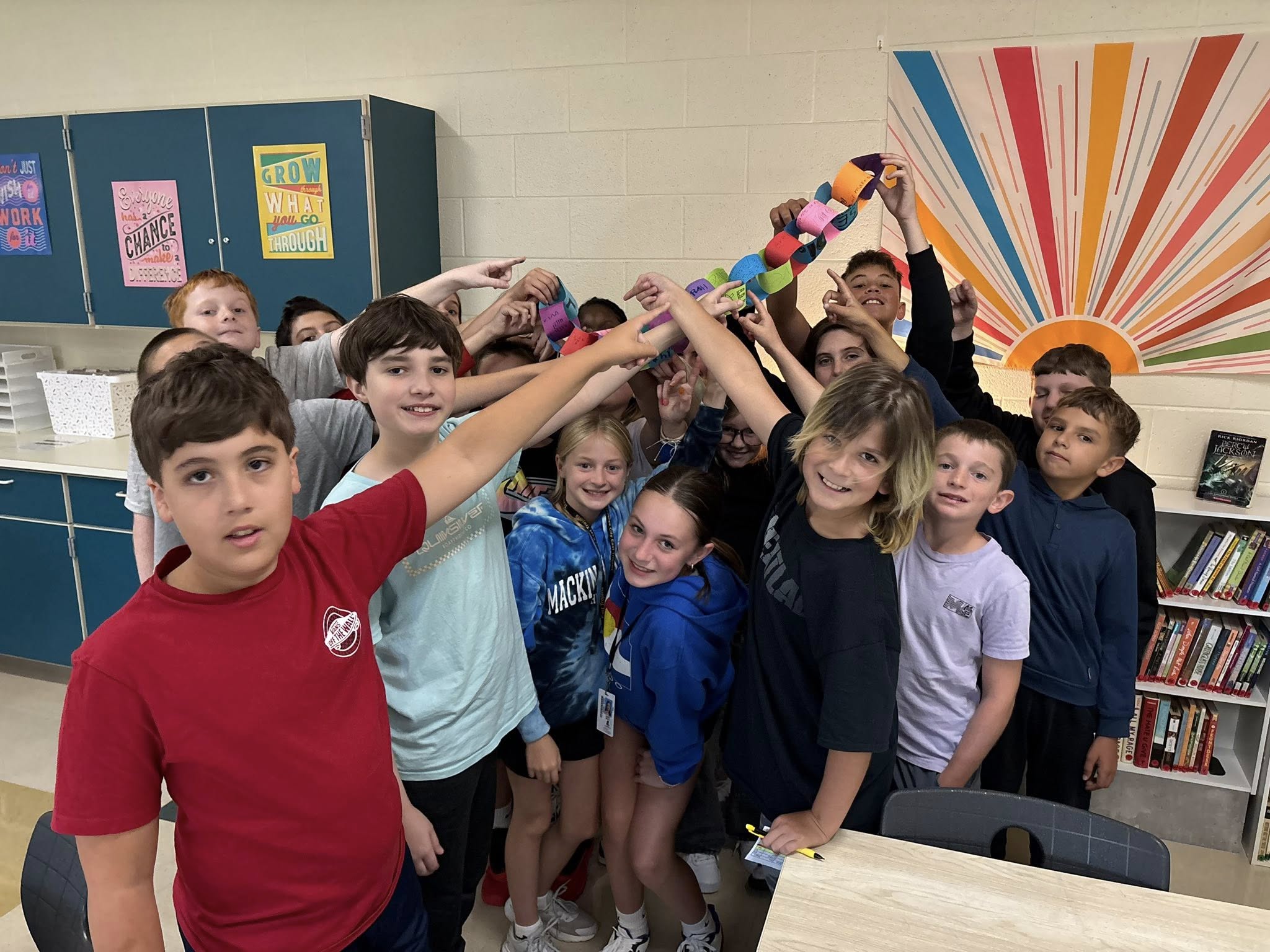 Students holding paper link in classroom