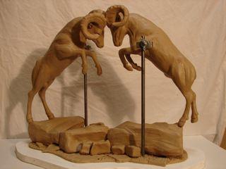 CLAY SCULPTURE OF TWO RAMS HEADBUTTING