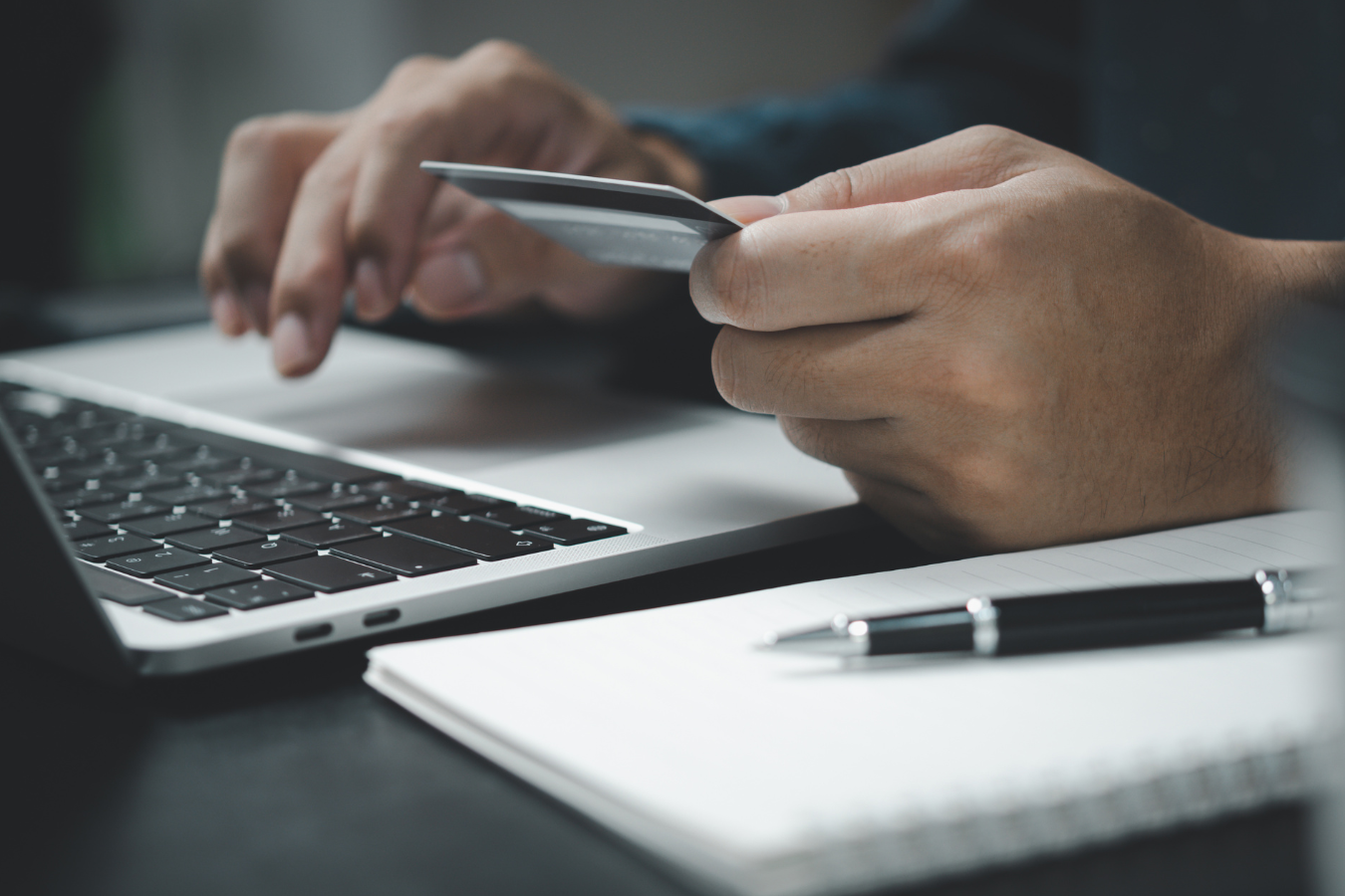 Person using credit card to make a payment using a laptop computer