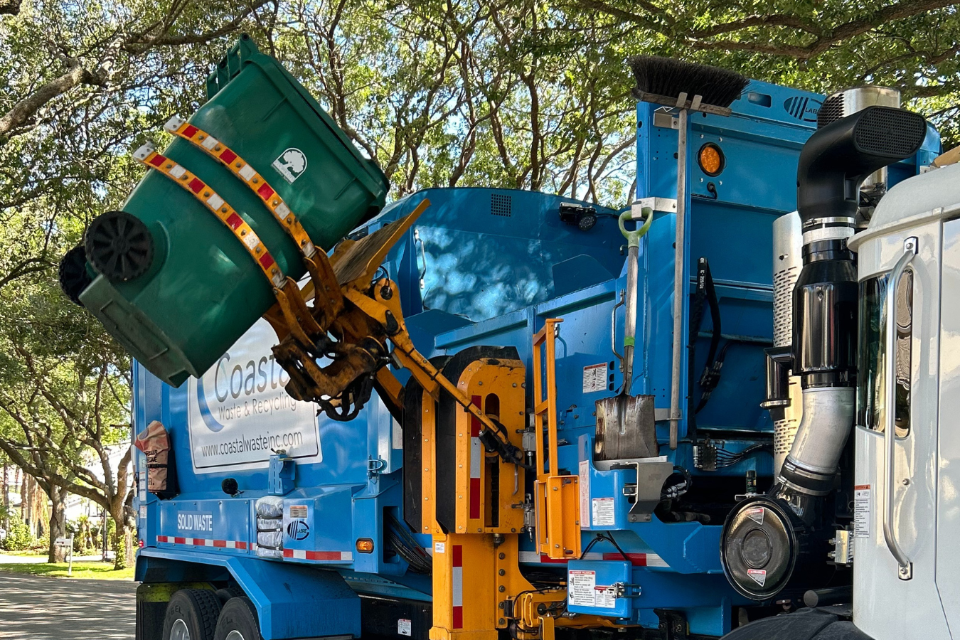 Garbage truck collecting waste from bin.