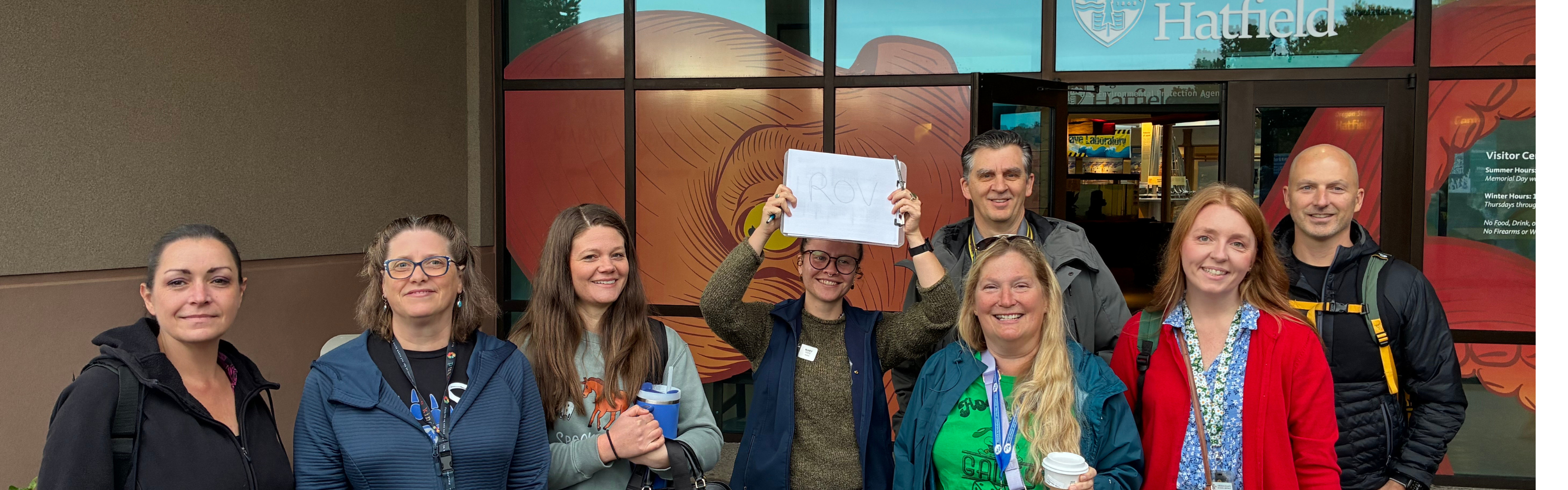 Group of middle aged adults standing in front of a building