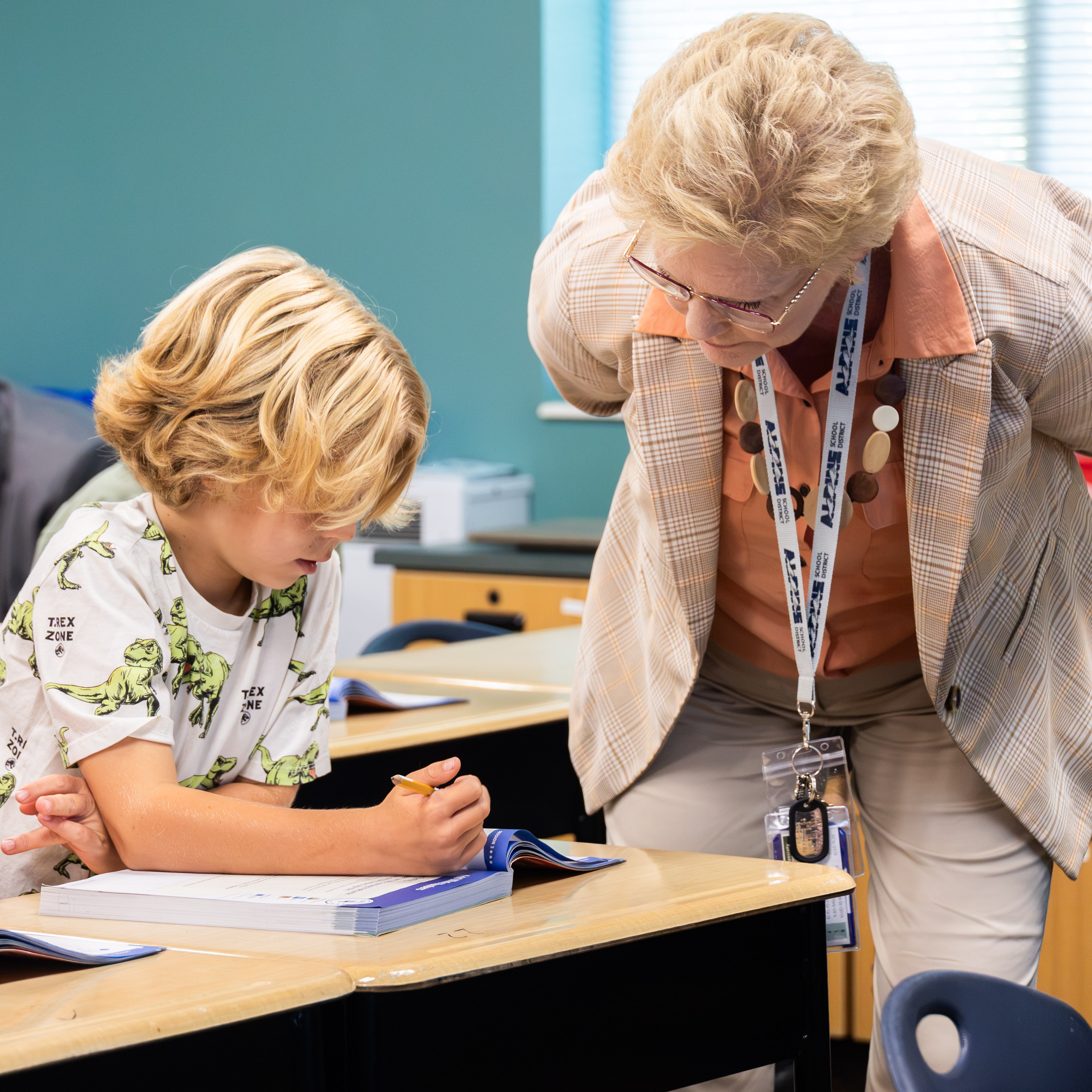 principal patrice worlton observes as a student works in a workbook