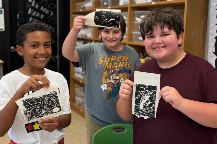 Students holding artwork
