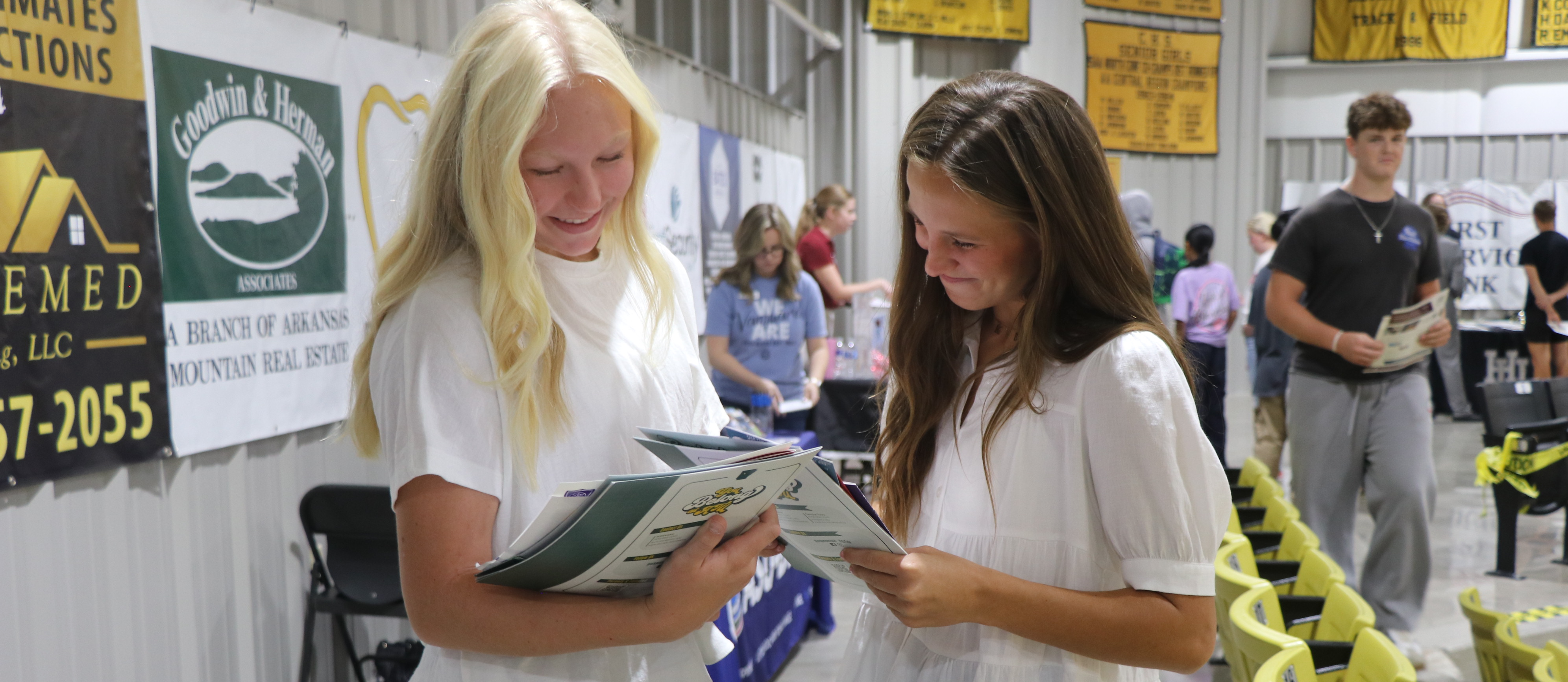 two girls reading a folder