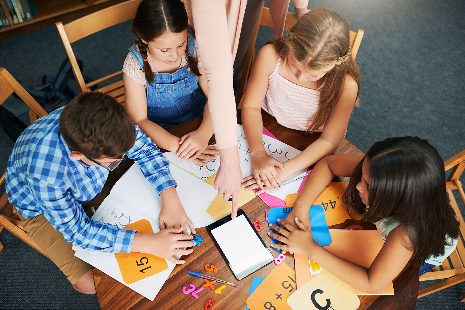 Students at table using manipulatives to learn mathematics