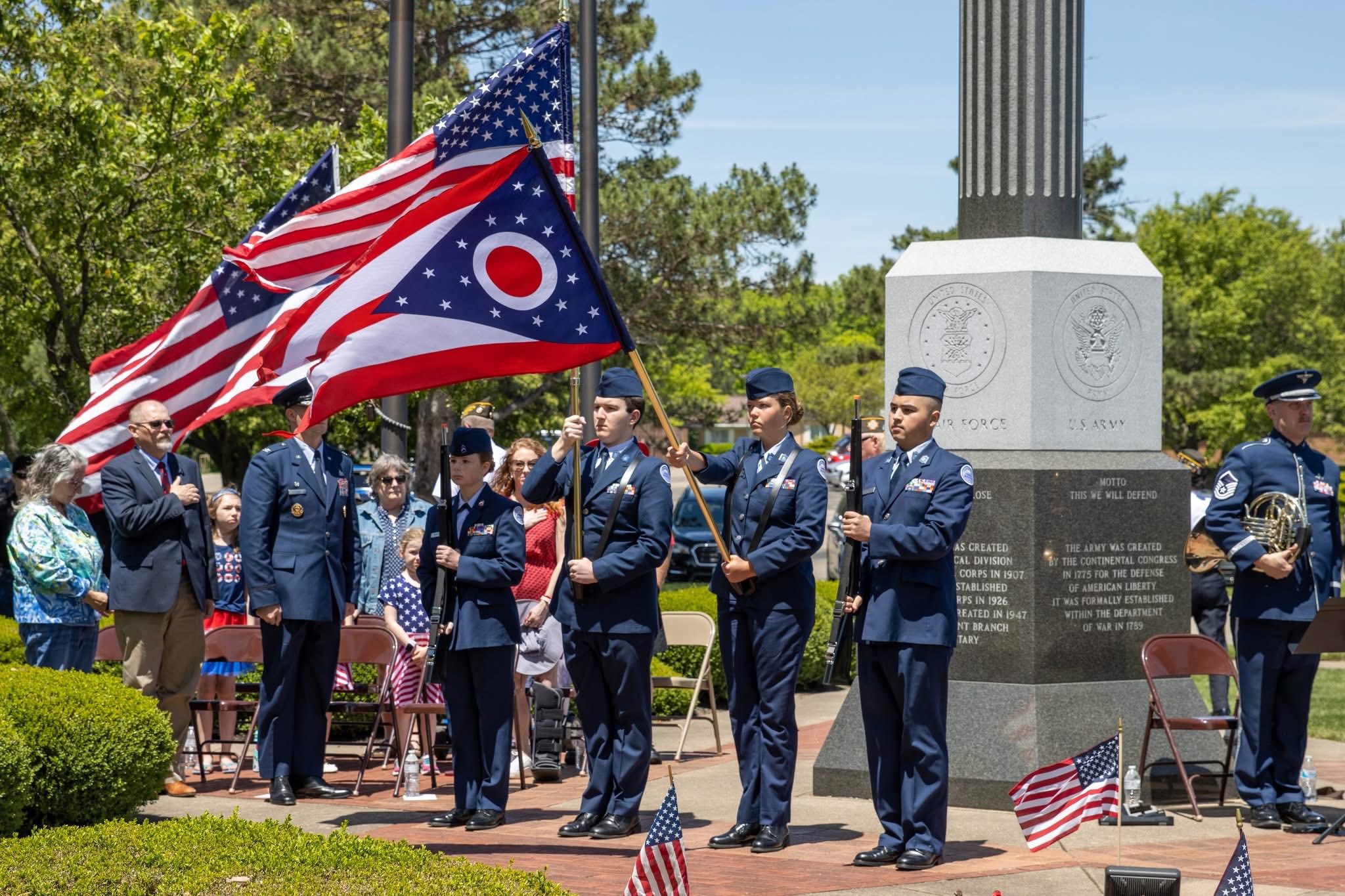 students in uniform presenting colors