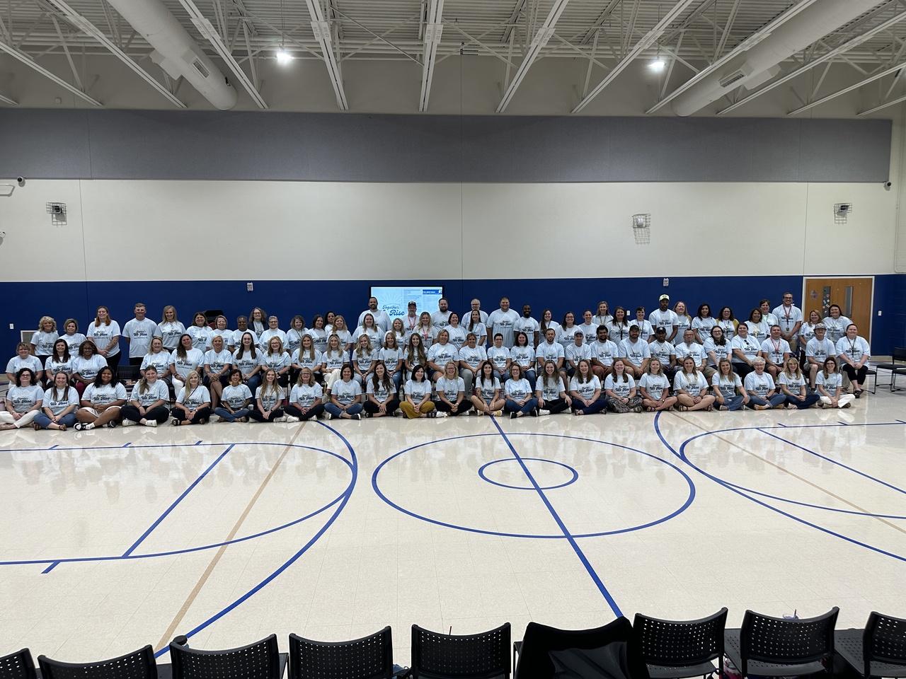 image of students within the gym on bleachers at a distance