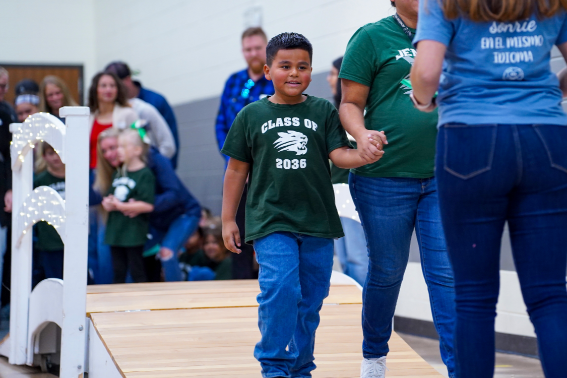 El Puente student walking across bridge during ceremony
