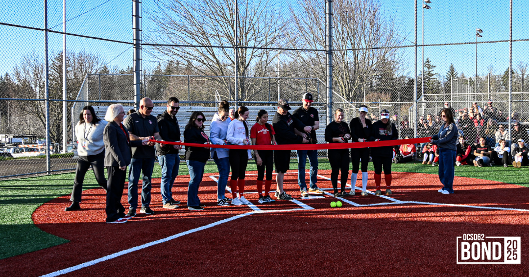 Members of the softball community and OCSD cutting a ribbon at the new OCHS Softball field