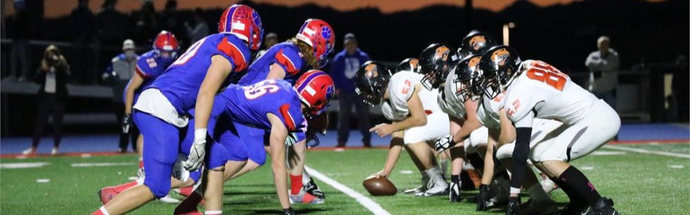 football players lined up with blue uniforms and white uniforms