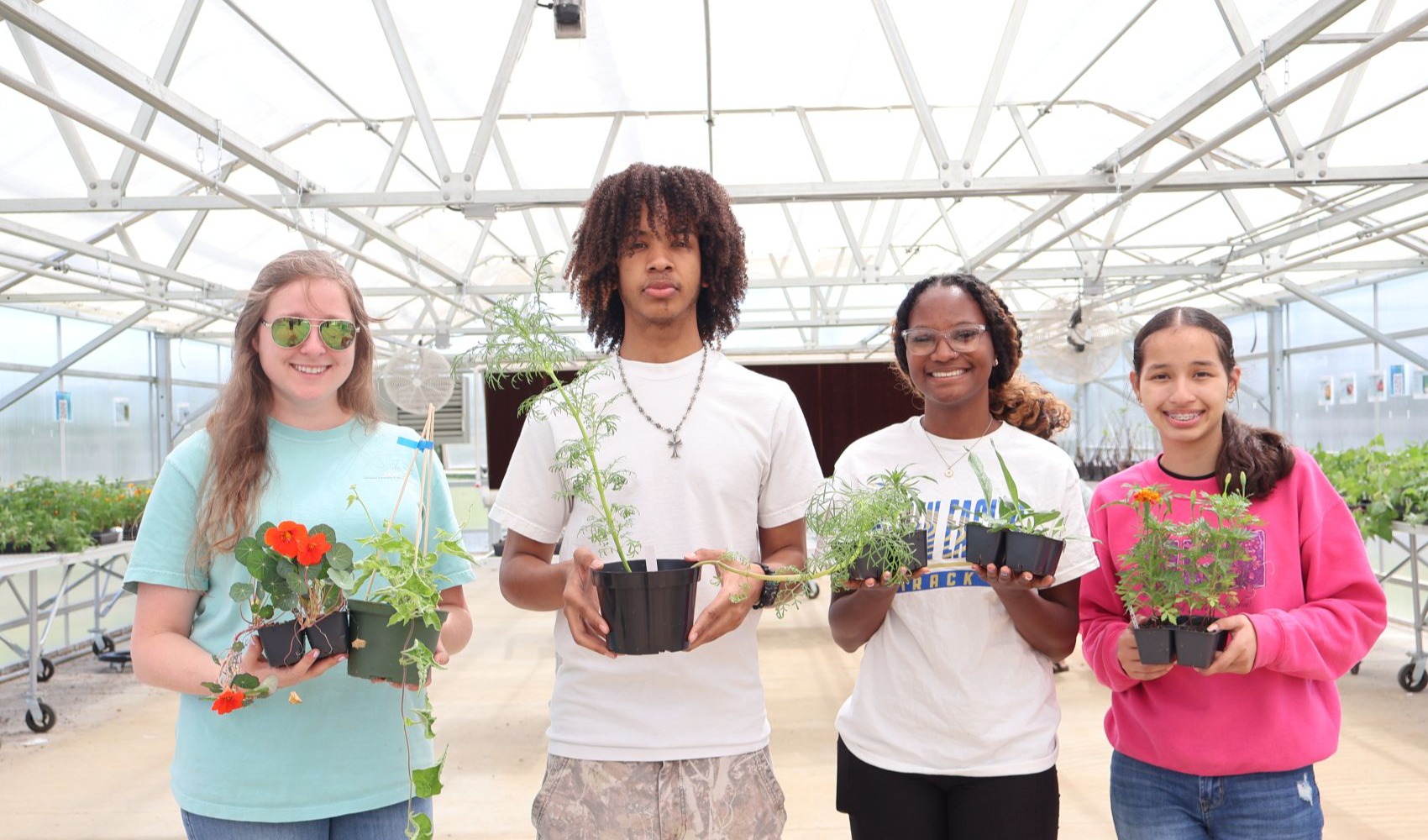 Students and their instructor pose for a picture inside of the greenhouse at the SCHS annex plant sale. 