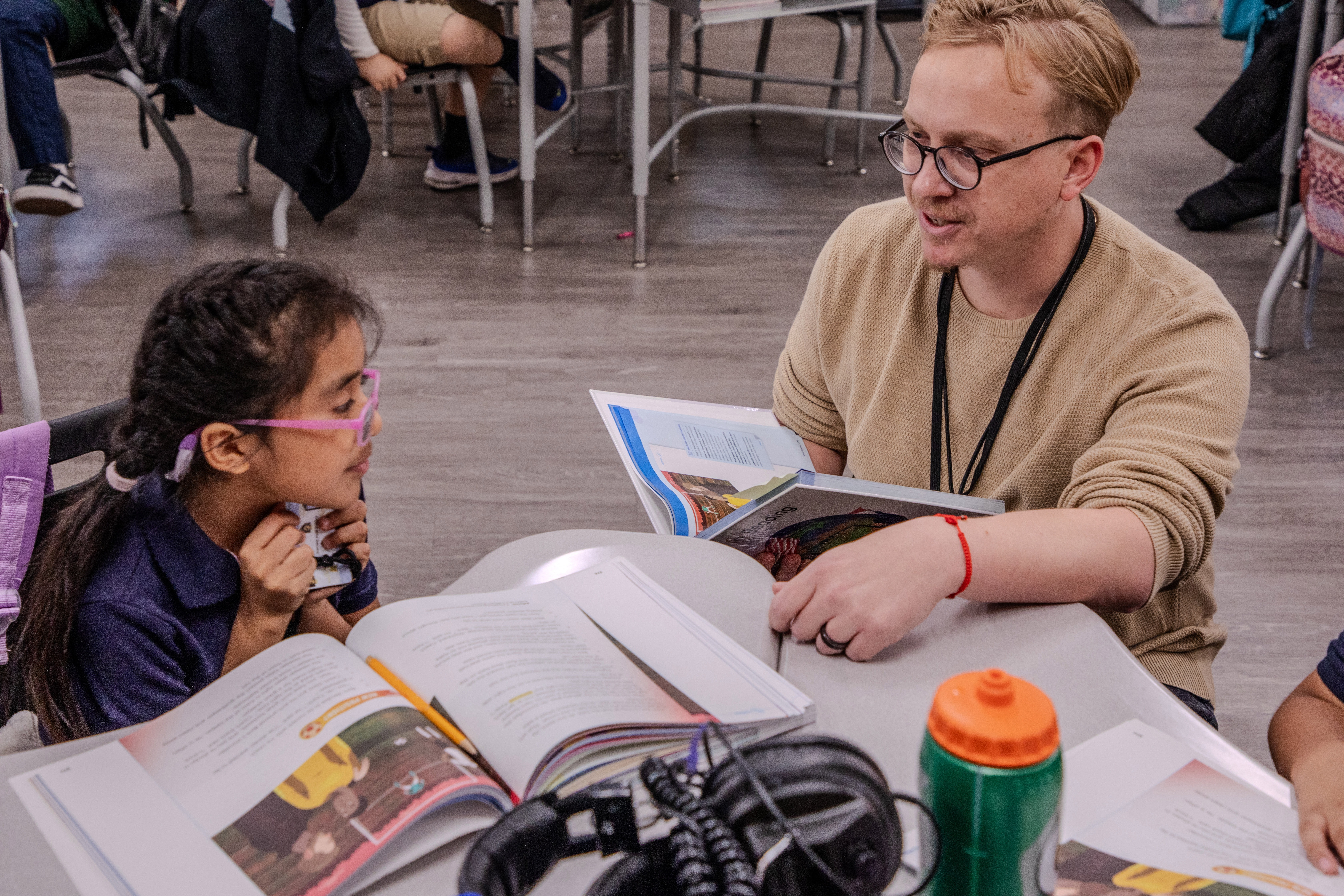 A teacher resident helps a student with work during class