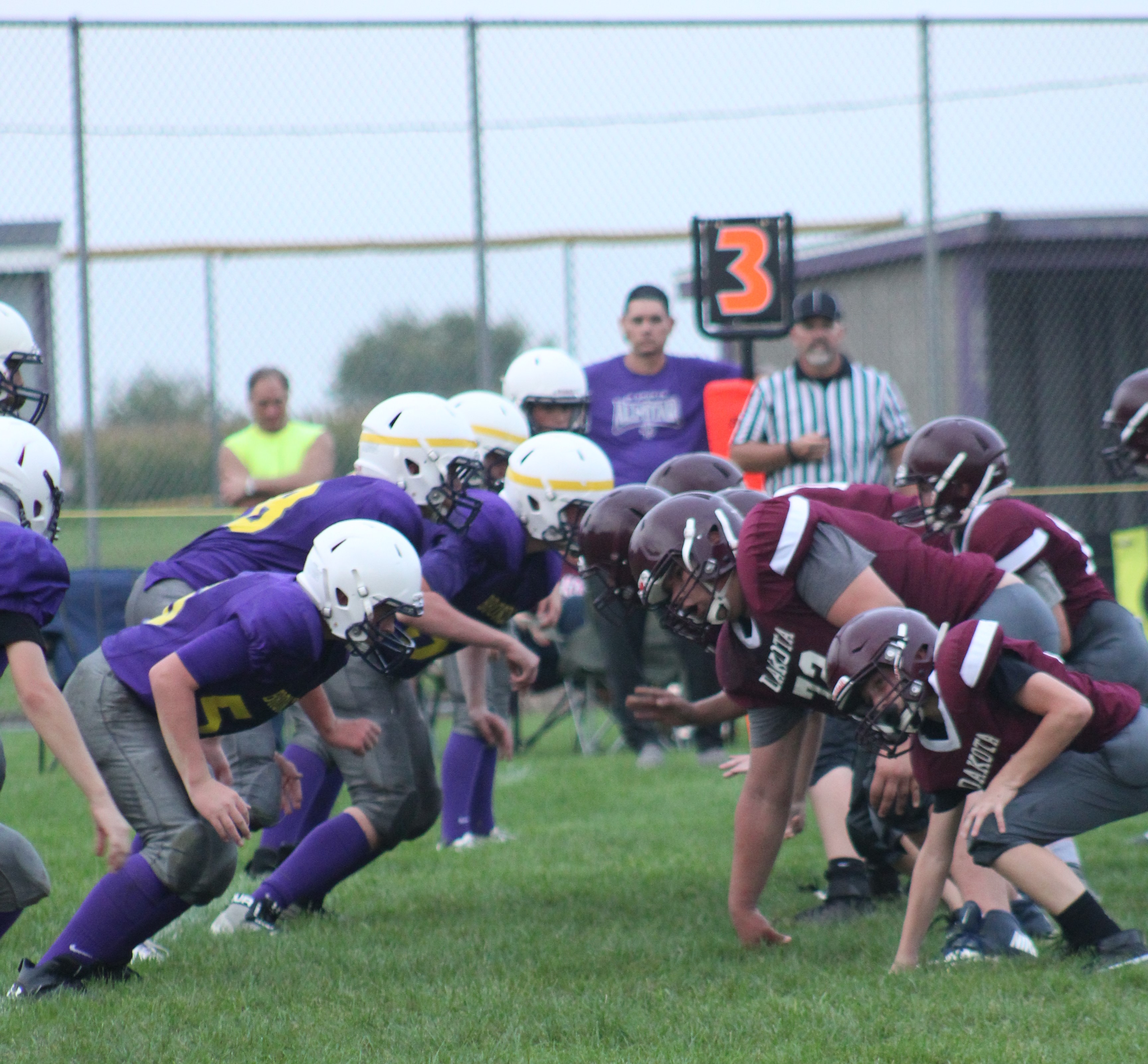 two football teams on the field facing each other at the line