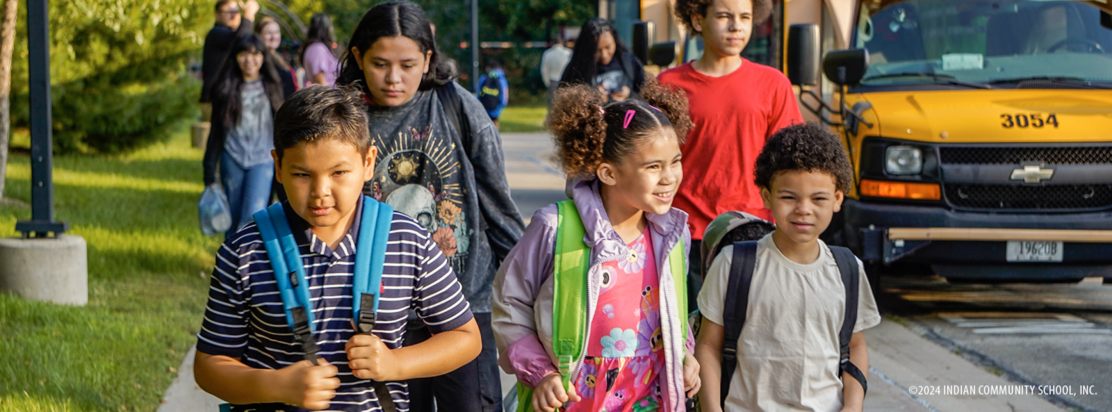students getting off of the school bus