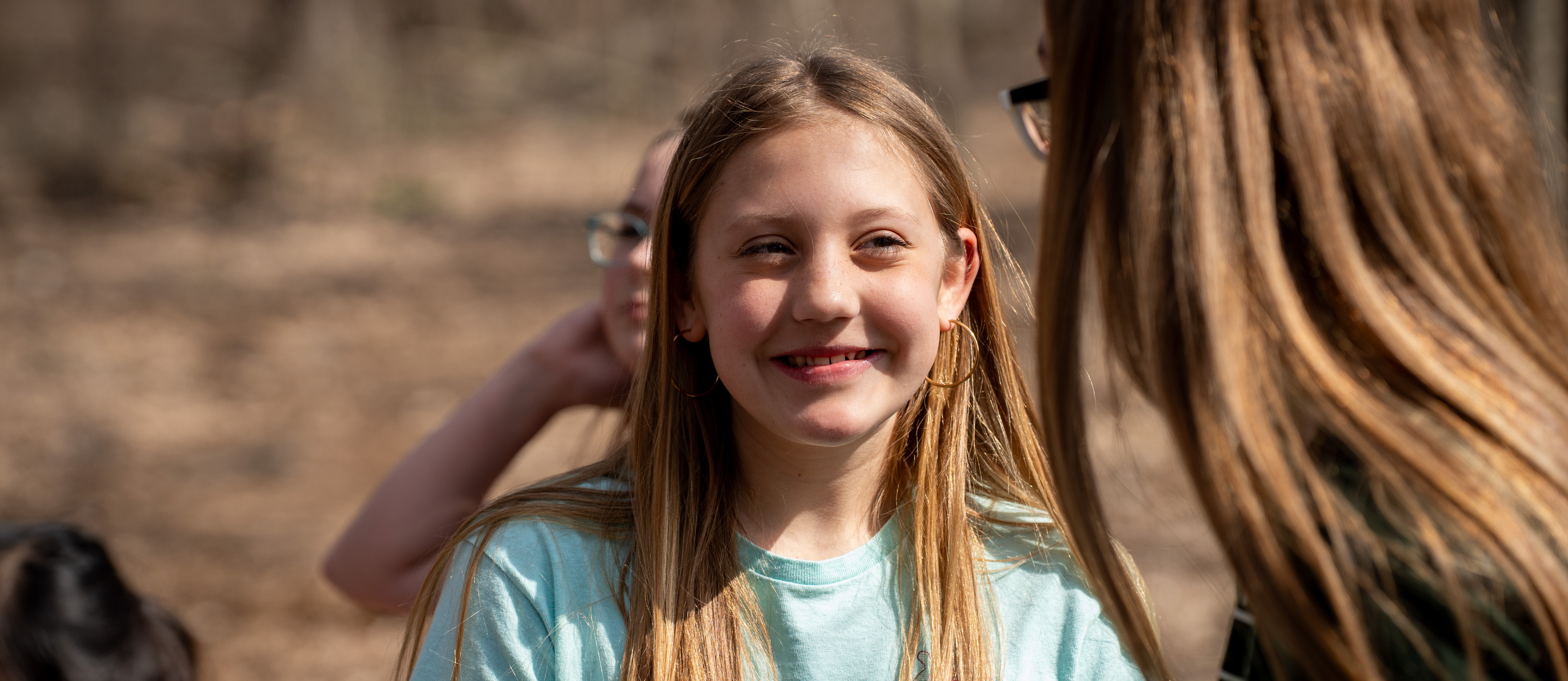 Student smiling in woods