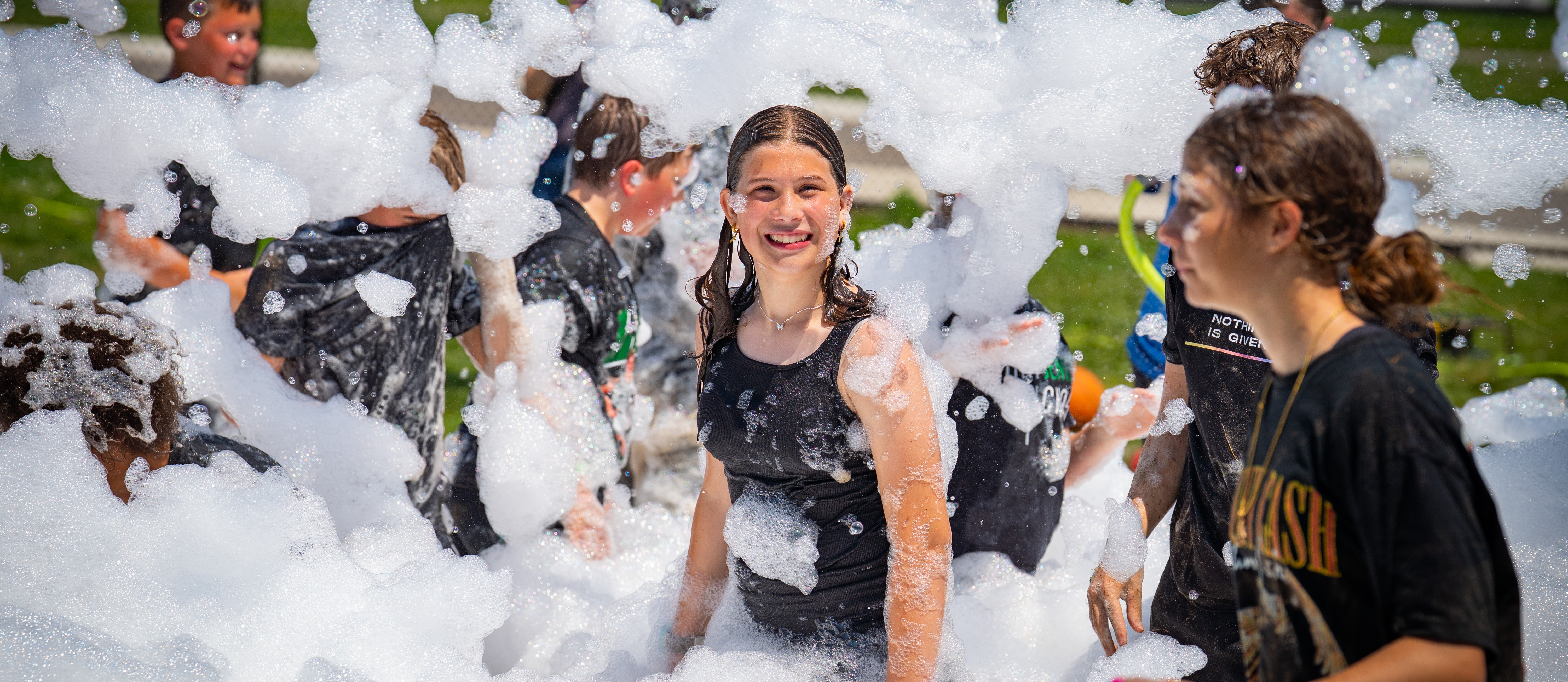 Students smiling at field day with bubbles