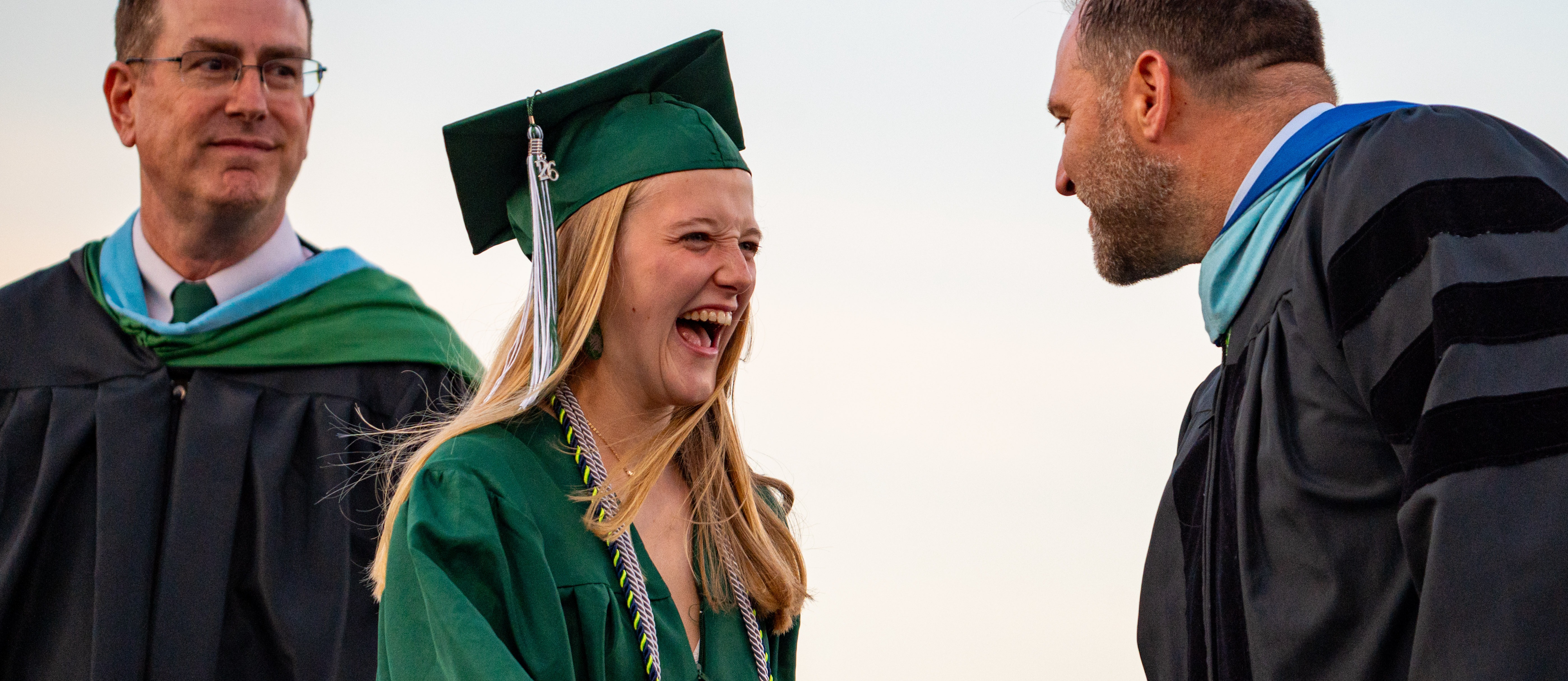 Female graduate smiling with shaking hand