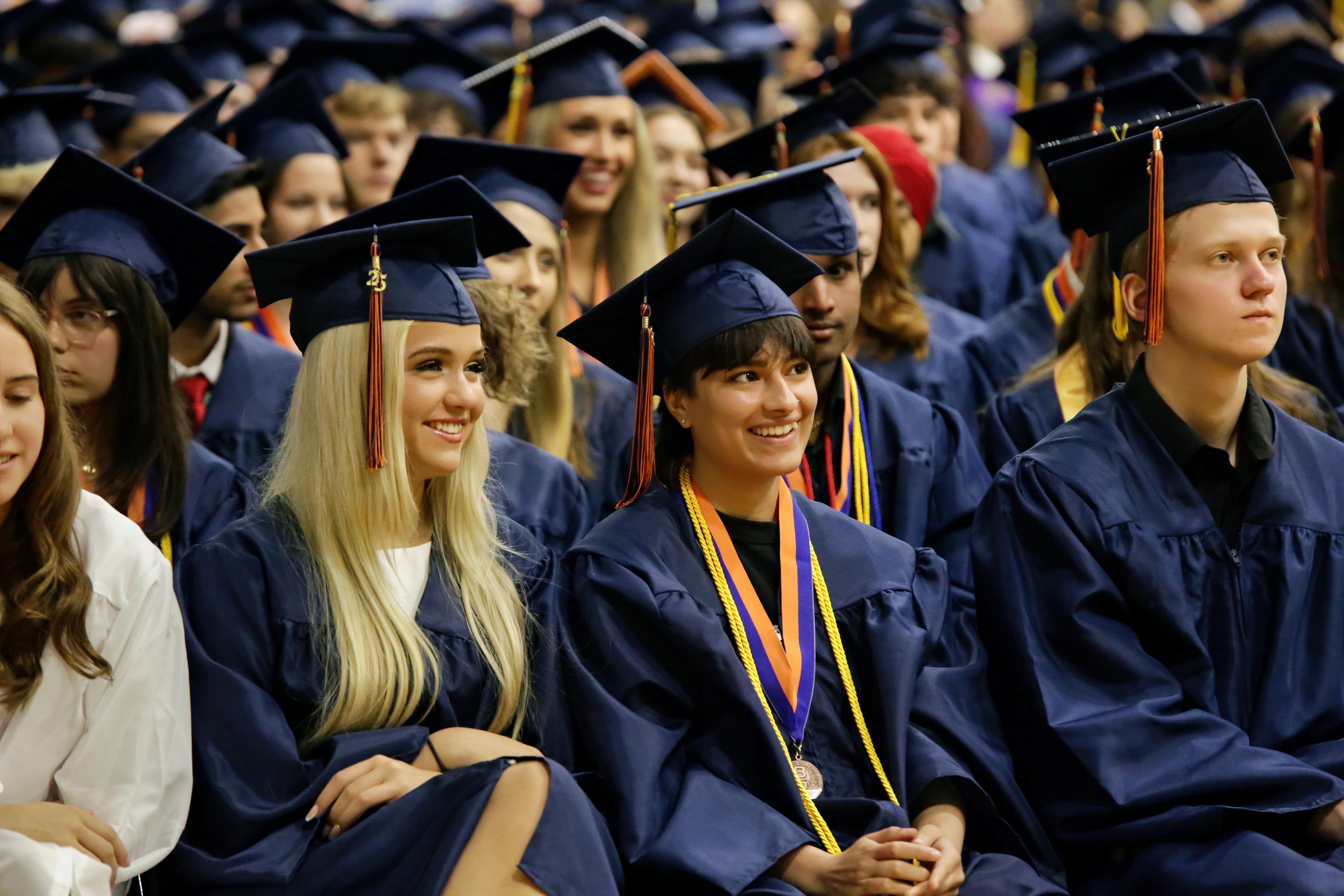 BGHS Graduates sitting at graduation ceremony in cap and gown