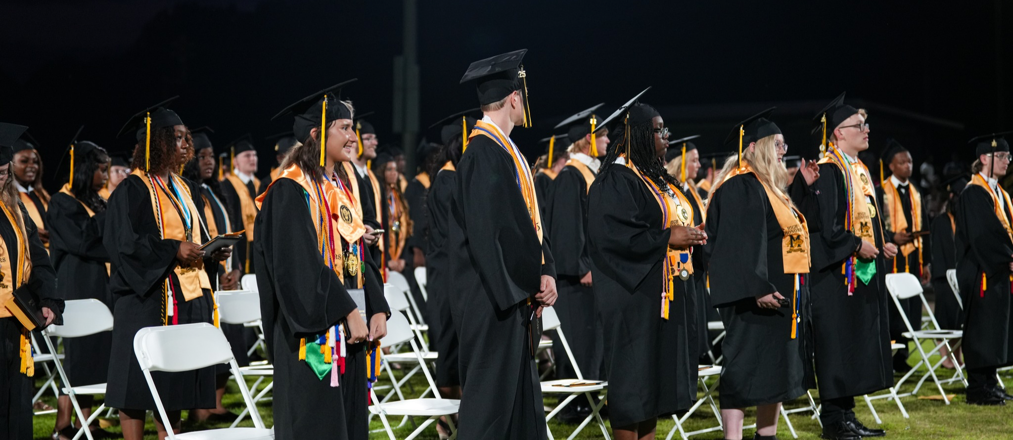 This is a photo of graduates standing at graduation. 