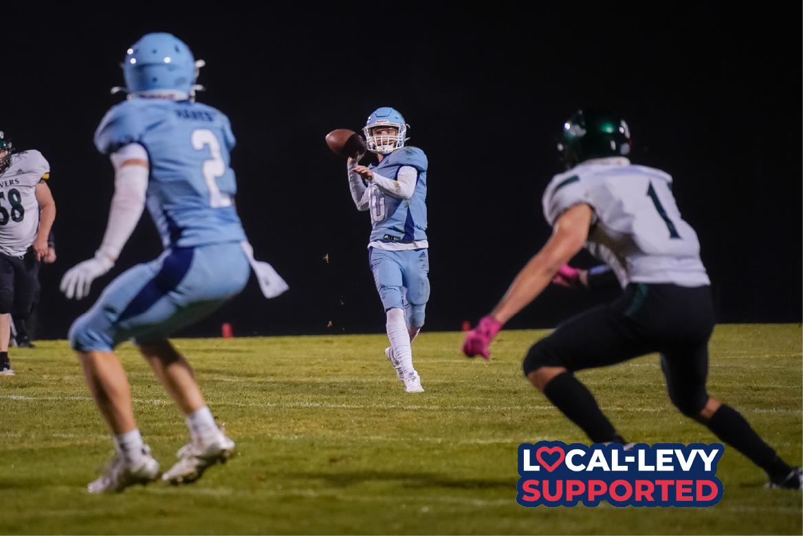 Football athlete throws ball to team mate