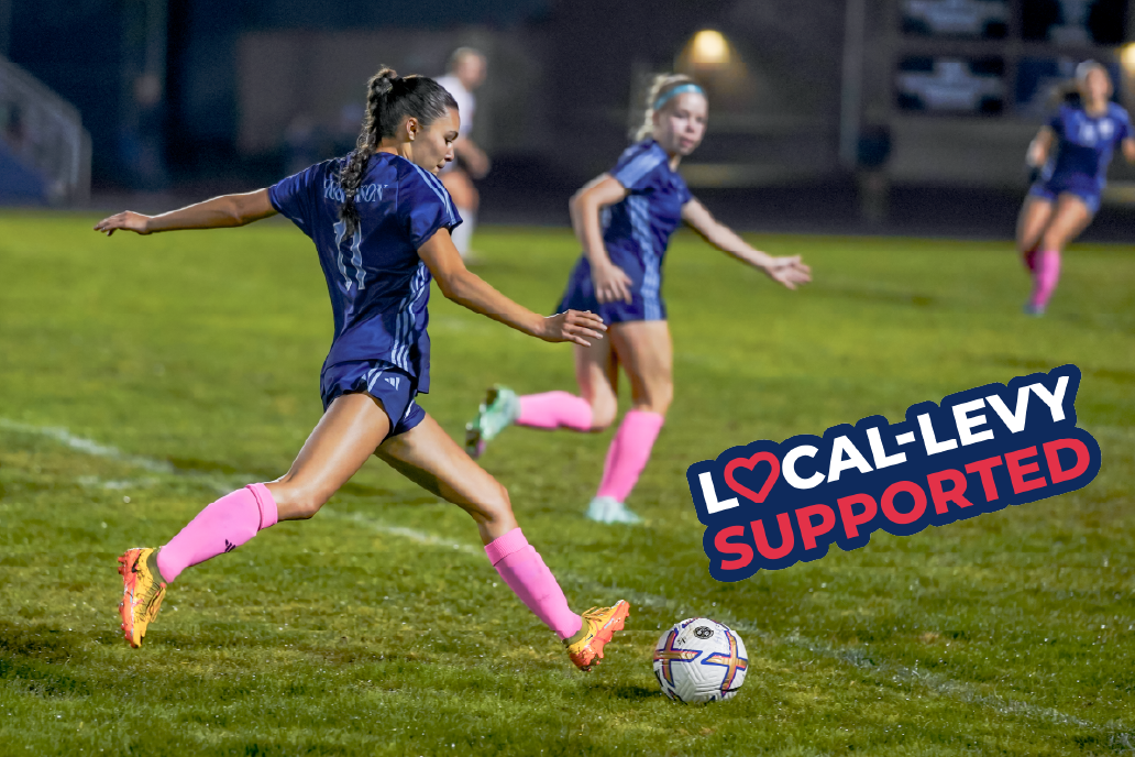 Girls soccer athlete kicks ball