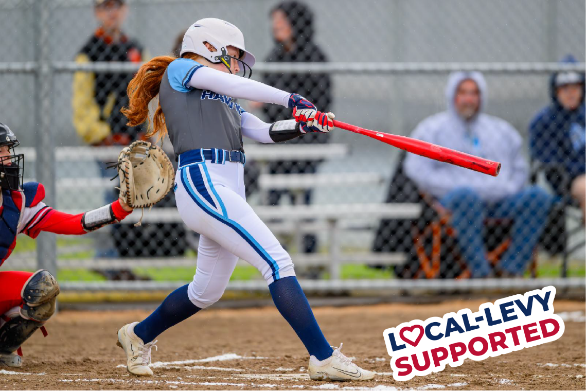 Girl swings bat on home plate