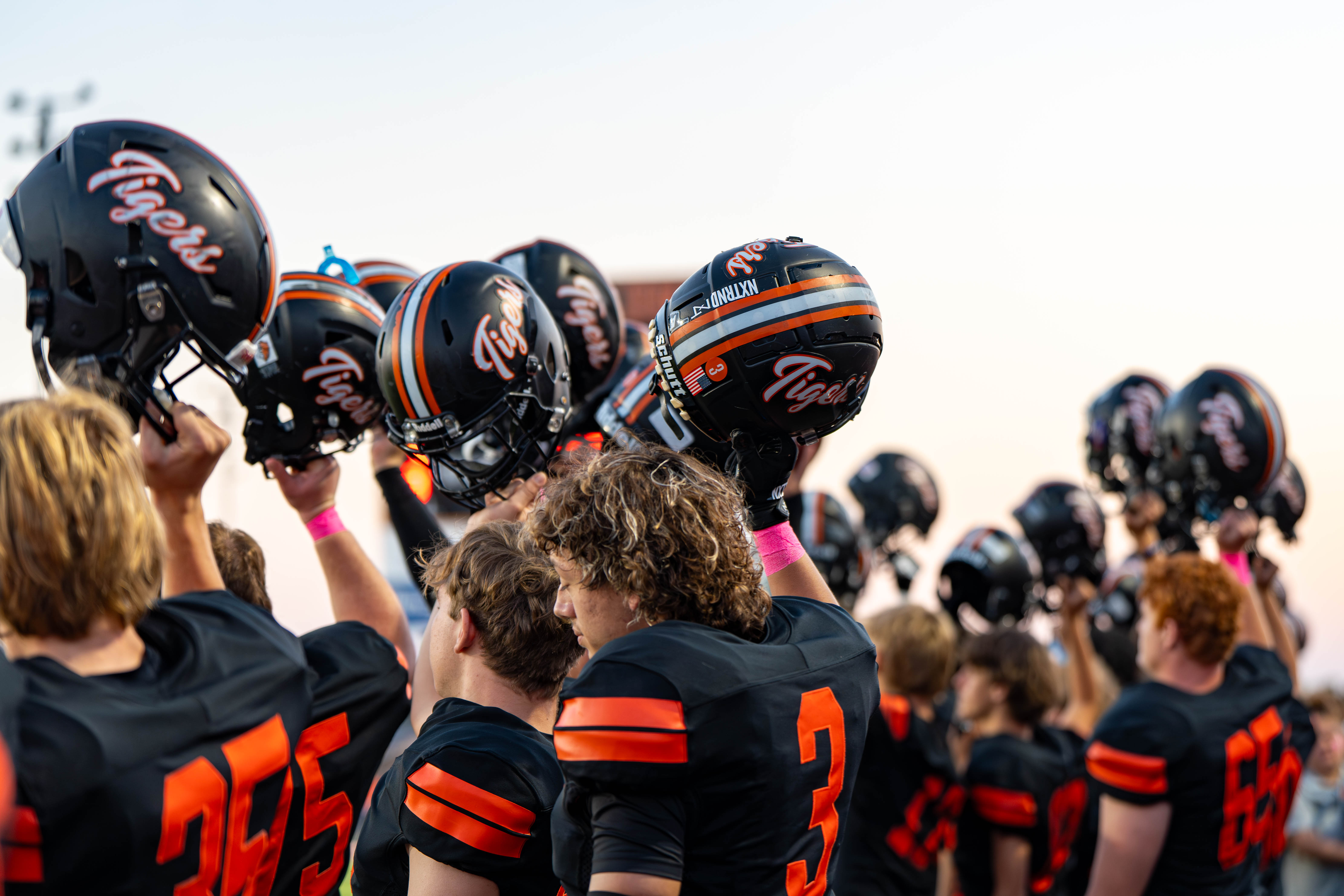 Football players holding their helmets