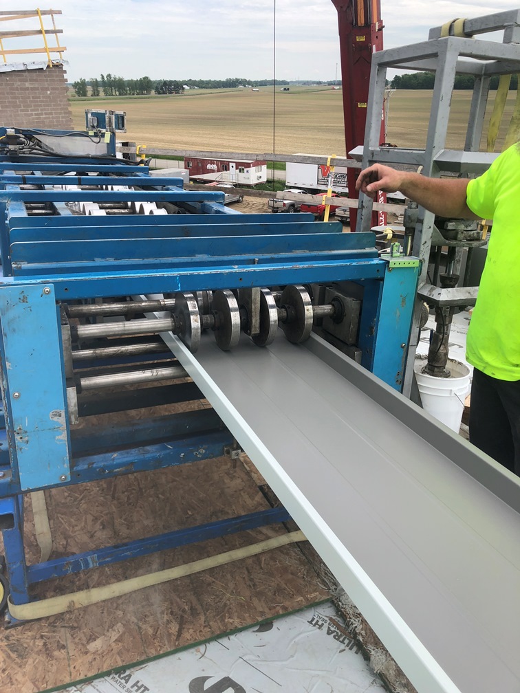 Photo of the Roof metal being formed on a machine on the roof.