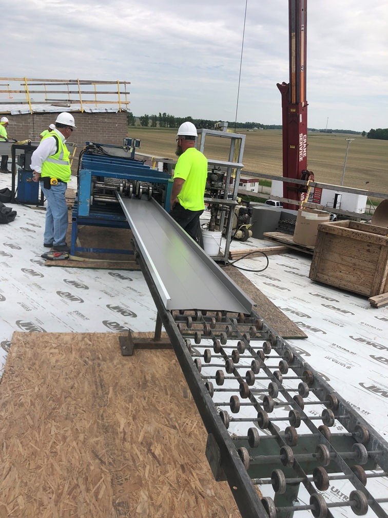 Photo of the Roof metal being formed on a machine on the roof.