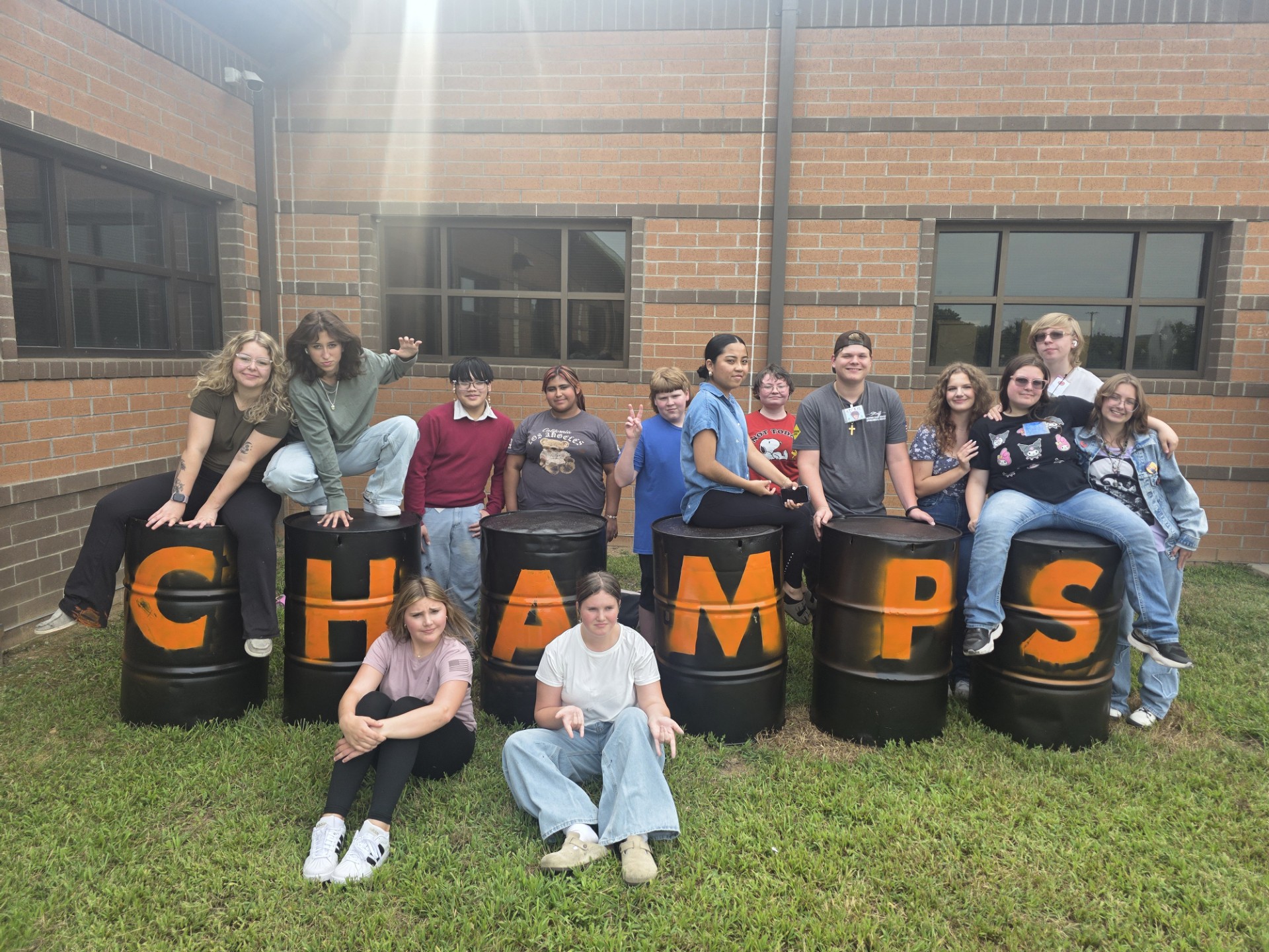 students pose with CHAMPS barrels to be used in student section