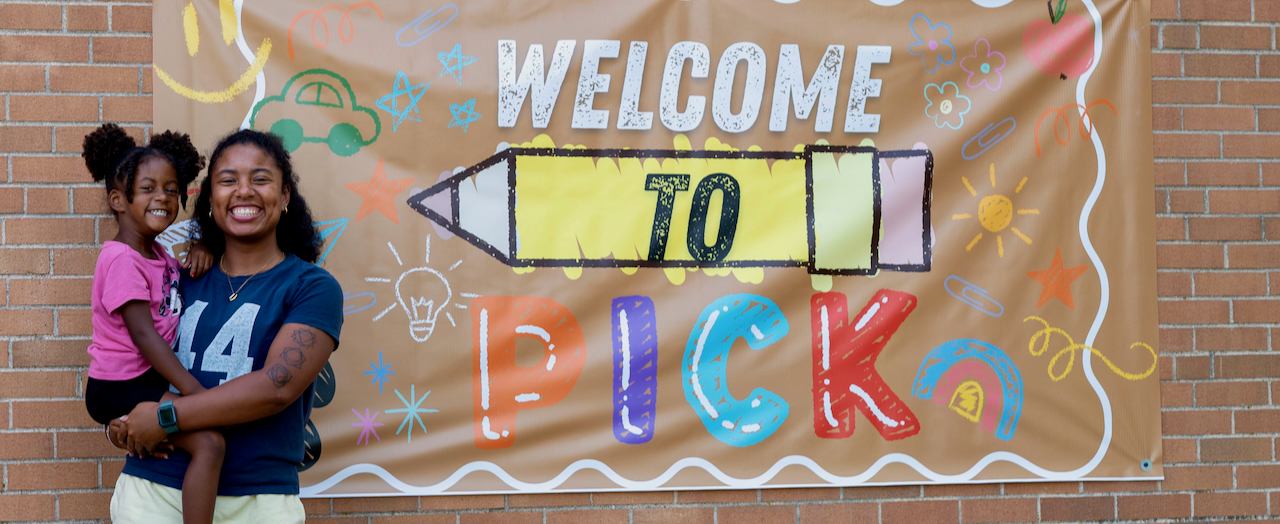 Parent and student outside Pick with welcome sign
