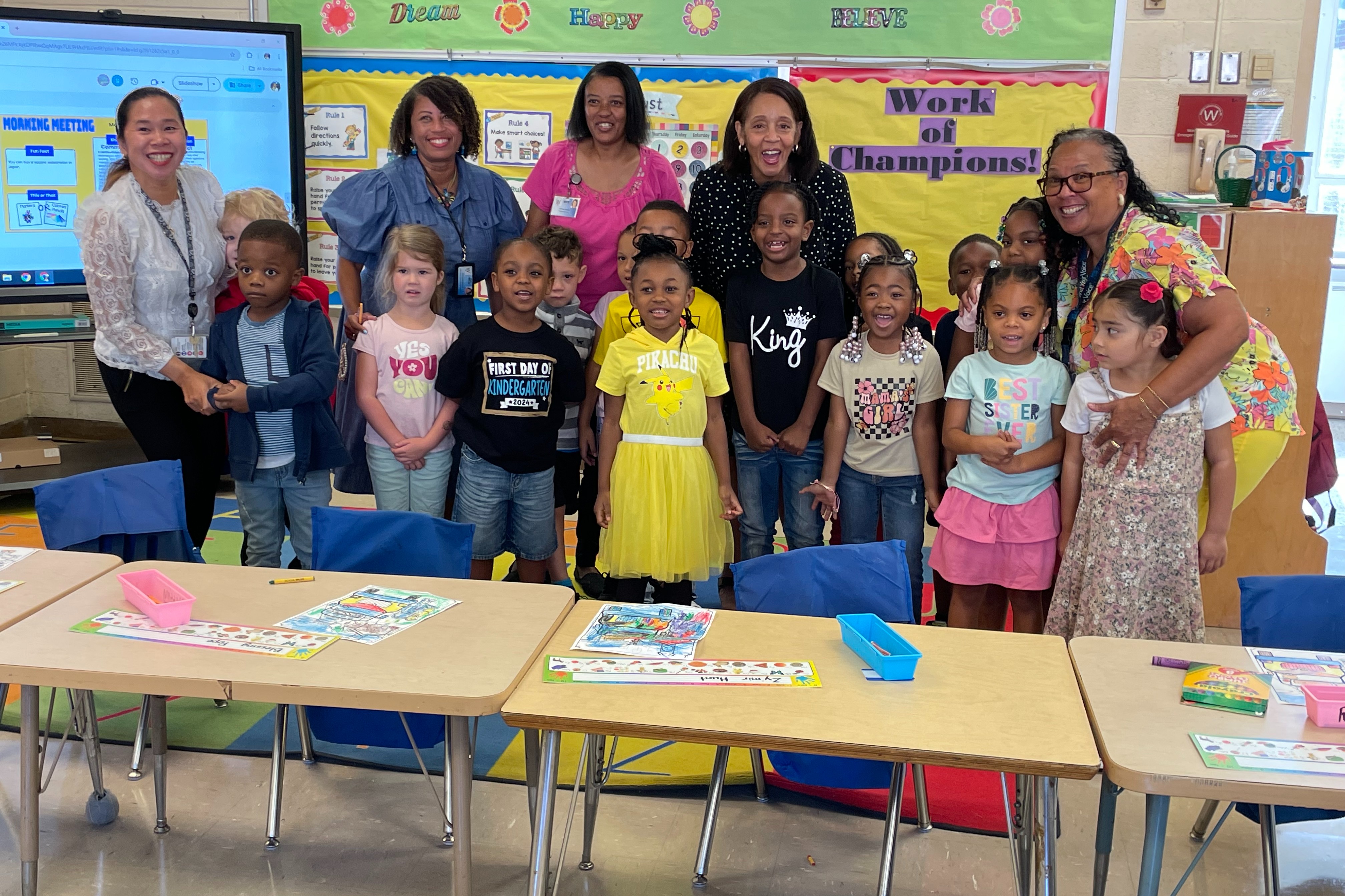students, teachers, the principal, and superintendent grouped together in a classroom smiling for a picture