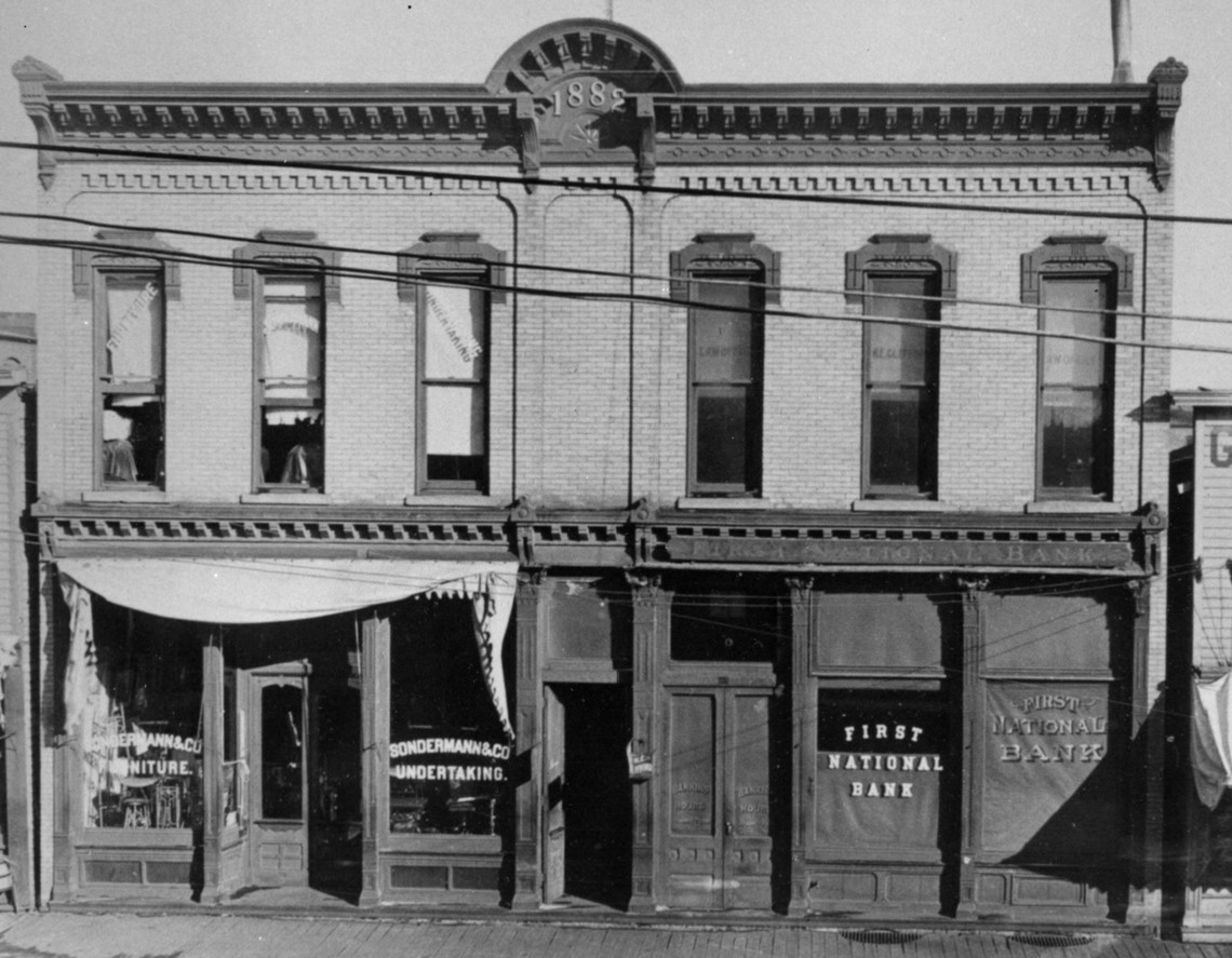  Livingston-Sondermann  The Chocolate Bar is located in part of a building that was built in 1882 and was the home of First National Bank.  The eastern portion, which has since been changed and is now Master Stylist, had the same exterior facade.    In 1891 Joseph Sondermann started Sondermann & Co. Undertaking and Furniture.  The business changed names in the 1930's to Livingston-Sondermann and in 1956 moved to Koenig Street.    During the 1940’s and 1950’s a clothing store named Cheatums Style Shoppe operated out of this location.  In the 60’s it became Pat’s Booterie and in the 70’s it was Brown’s Shoe Fit.  The Picadilly Dinner Theatre operated from this location until around 1996.  The building is now owned by Amos and Sherena Anson who purchased it in 2007.