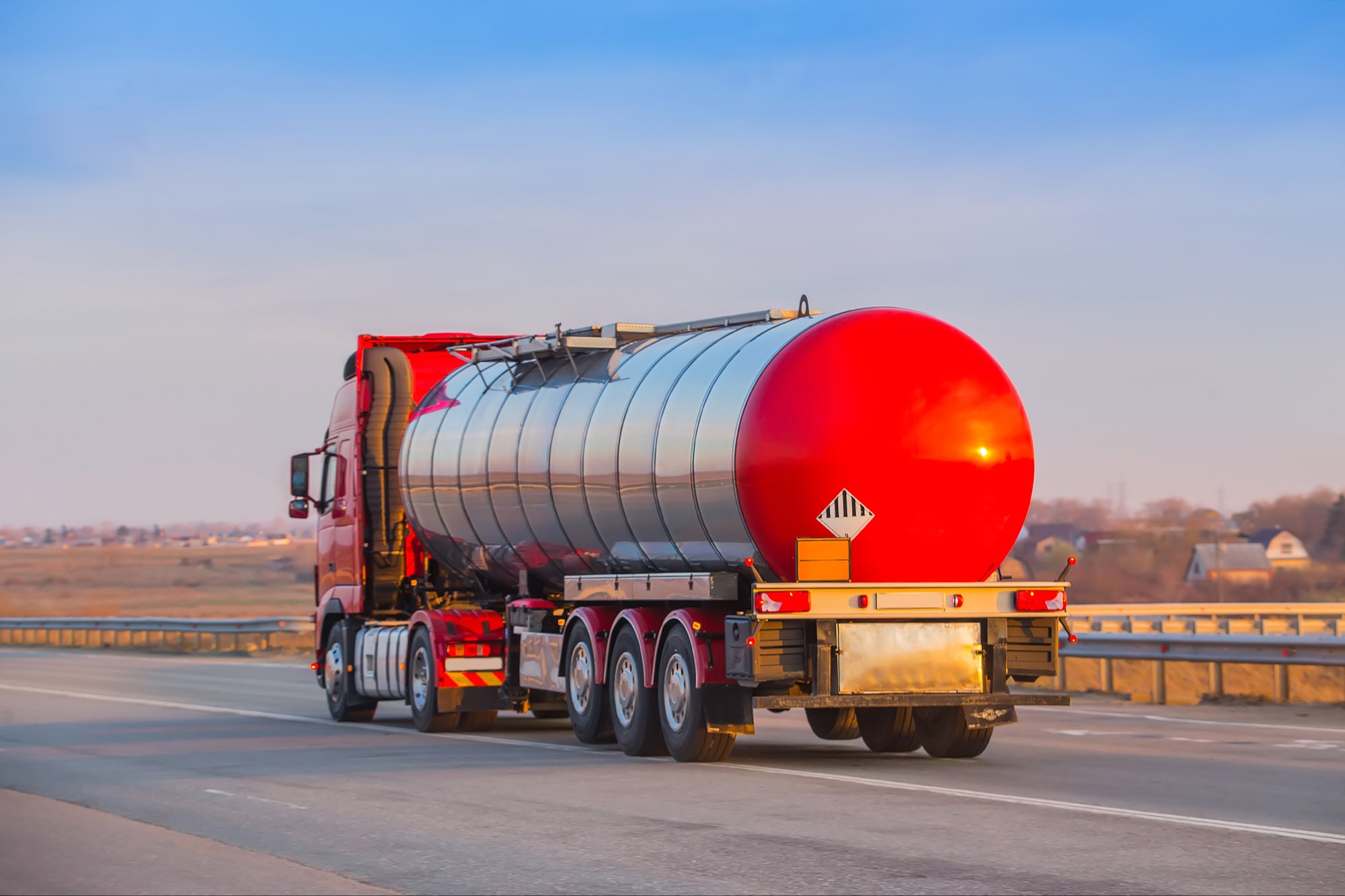 red semi hauling hazardous materials on a road