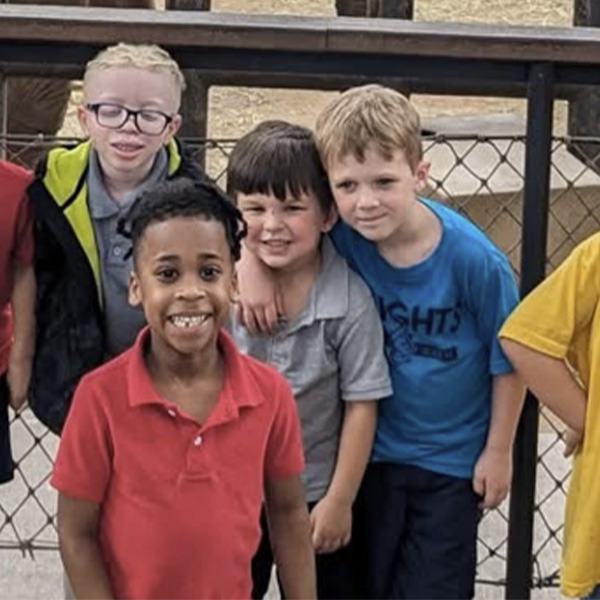Four students on a field trip stand together