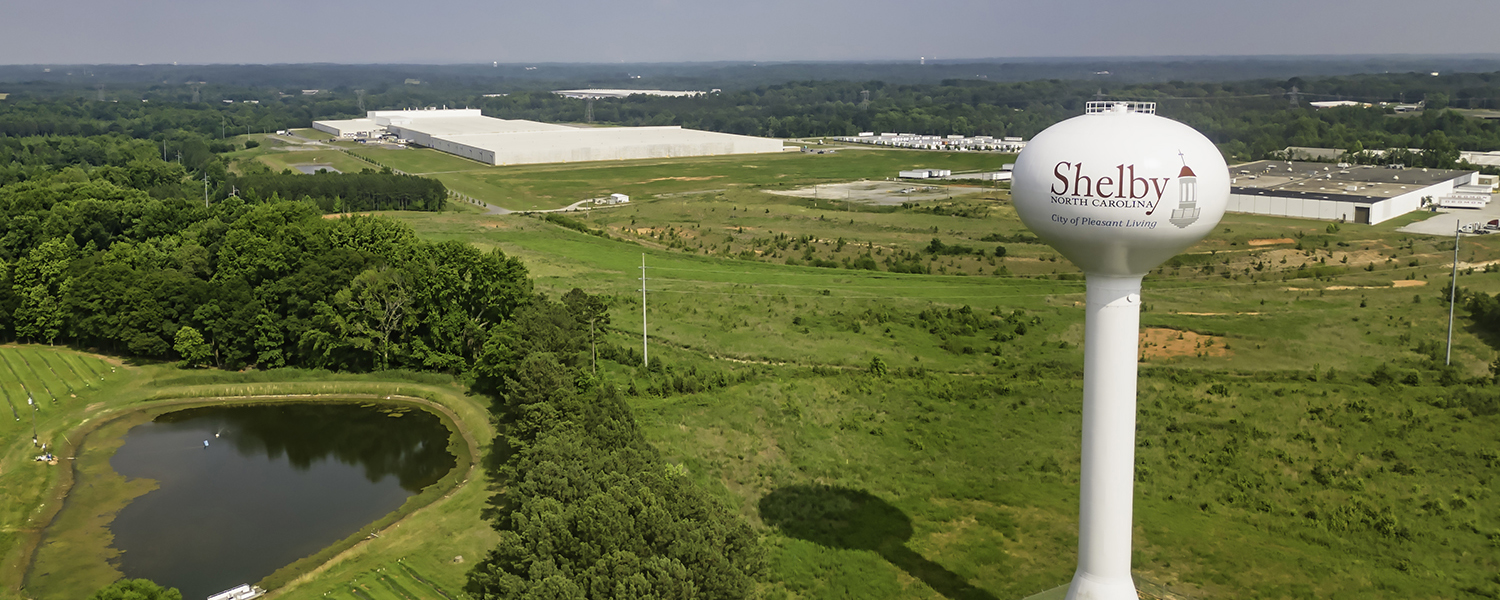 Aerial shot of City of Shelby water tower with industrial buildings in the background