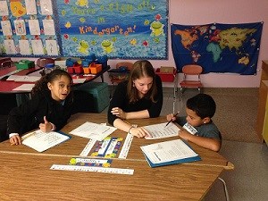 Children Learning with Teacher at Desk