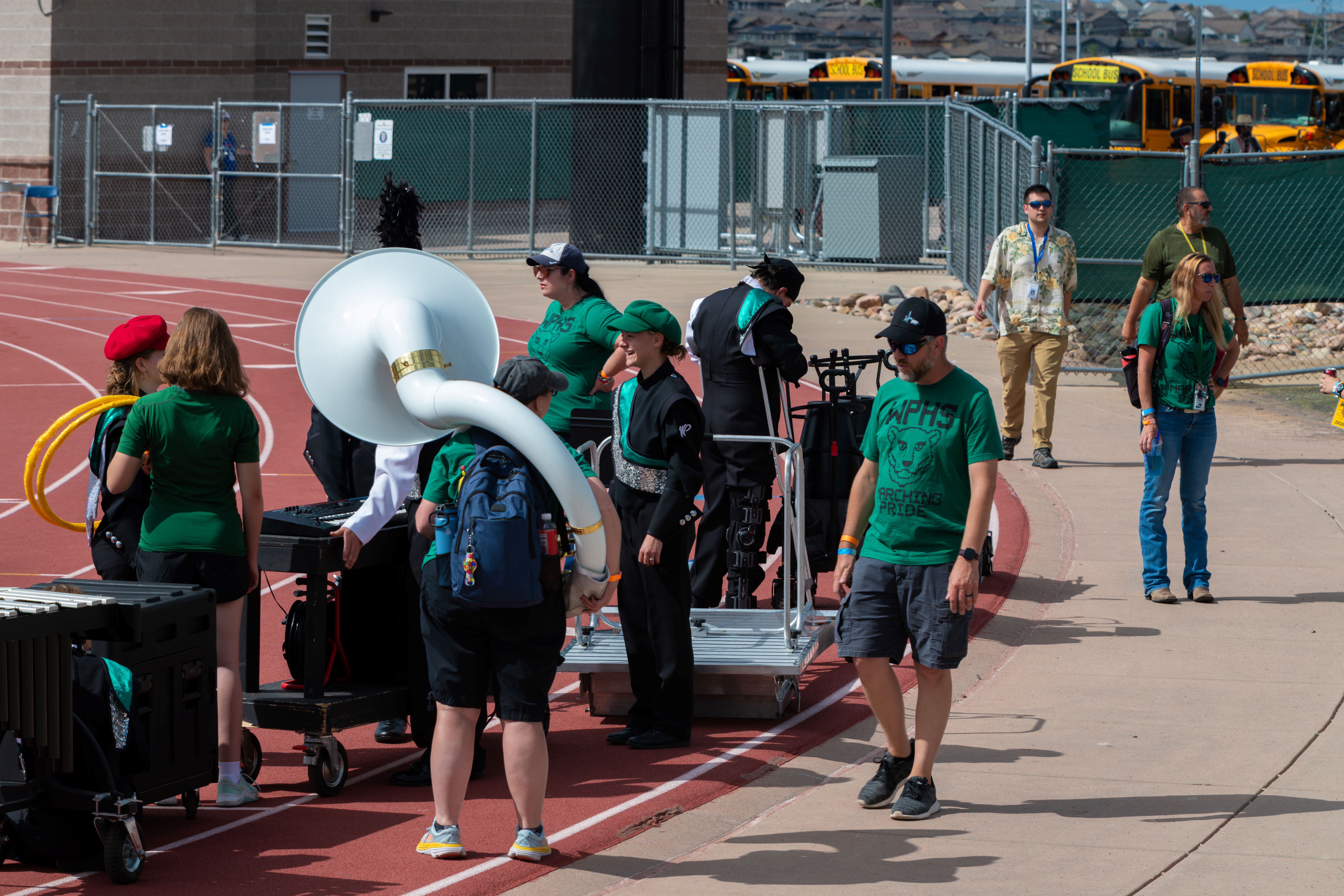 parent volunteers helping to move equipment at a marching band competition