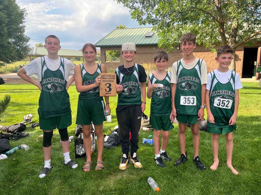 Jr High Cross Country team members holding awards