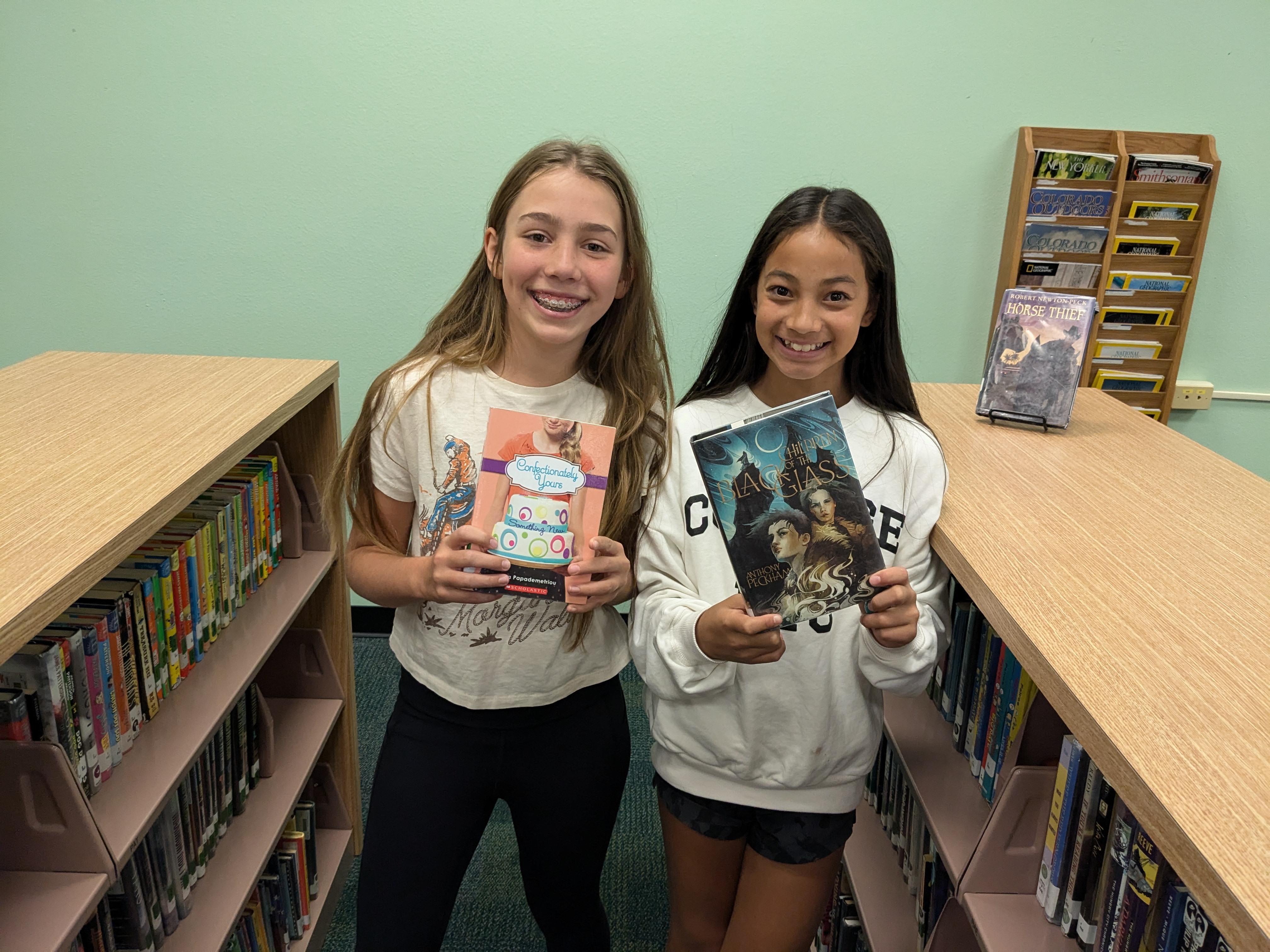 Two students showing us the books they've checked out