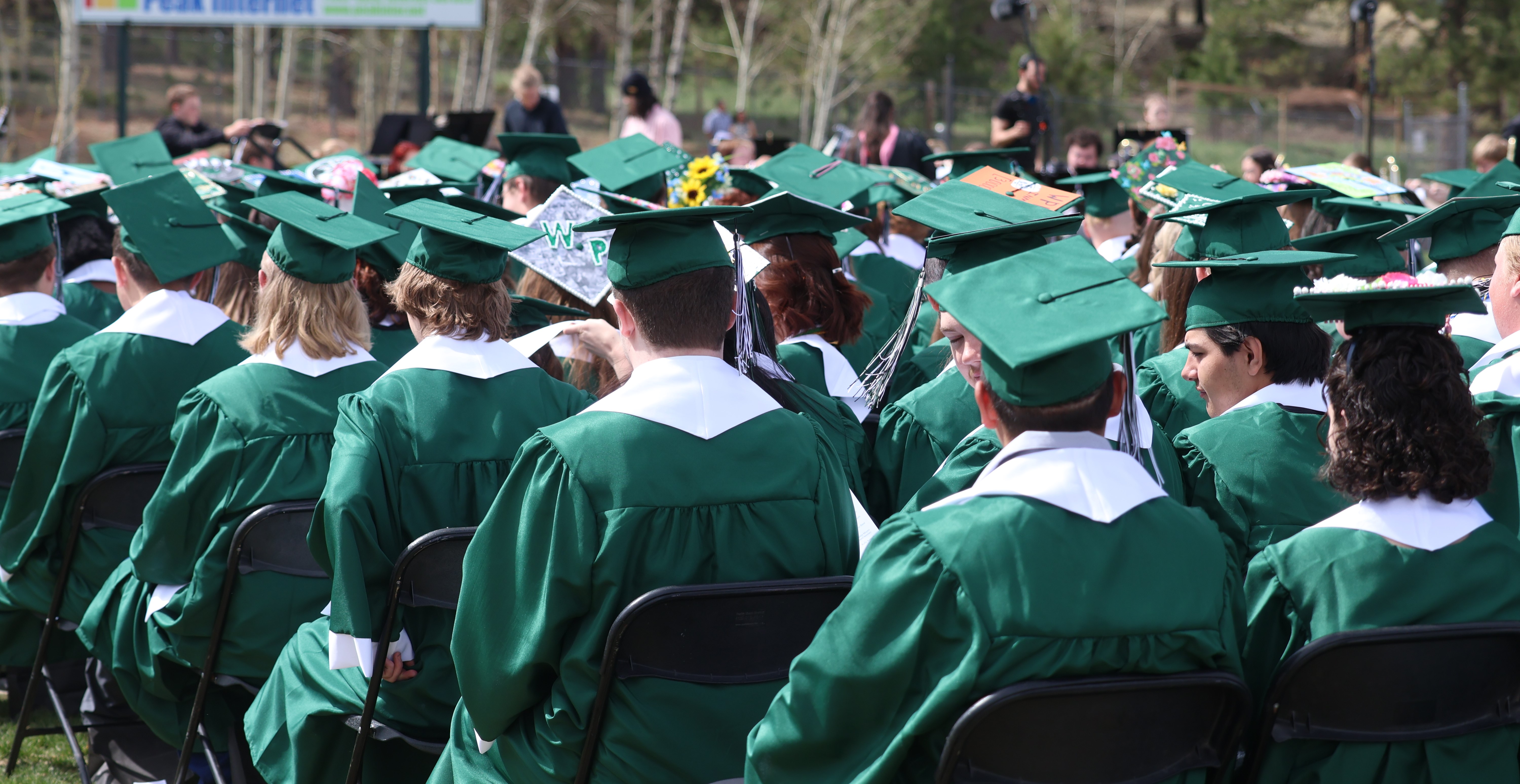 Graduates in caps and gowns sitting at the ceremony