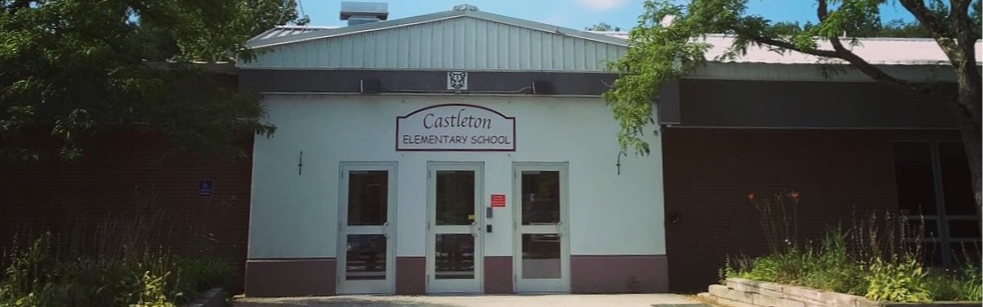 Front entrance of Castleton Elementary School, showing the school sign above 3 doors. Some clouds in a blue sky.