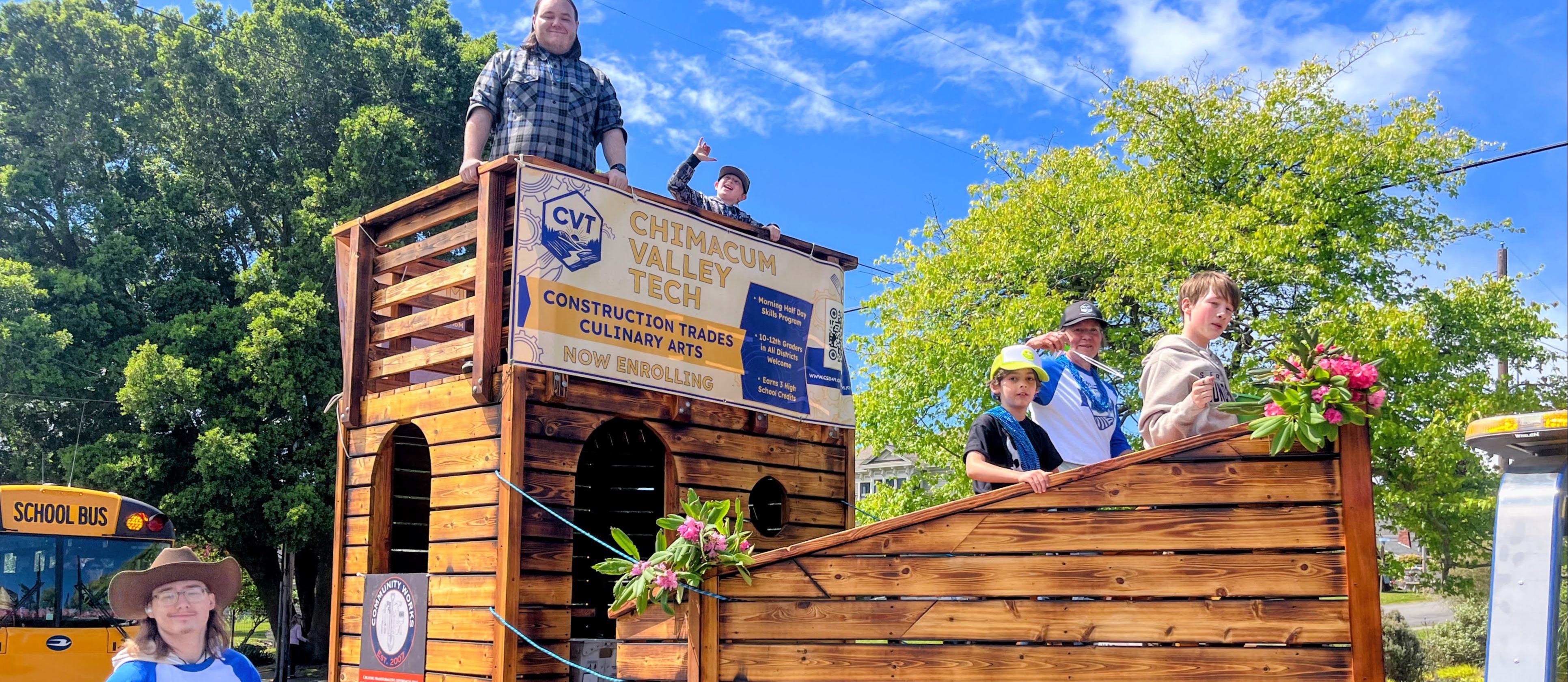 Students walk with student build ship in the Rhody Parade.
