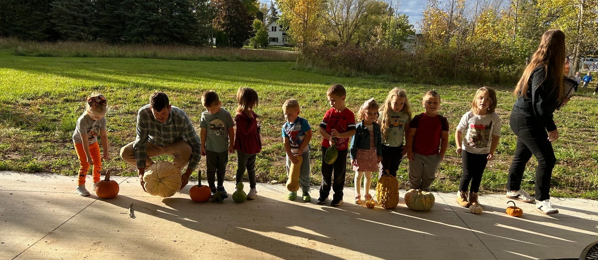 Elementary students carving Halloween pumpkins