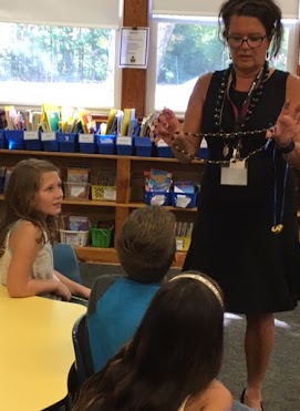 Mrs. Ashley from Sanford Institution for Savings shows the students how instead of money, people traded or exchanged non-monetary items (shells, grain, livestock) for things they needed