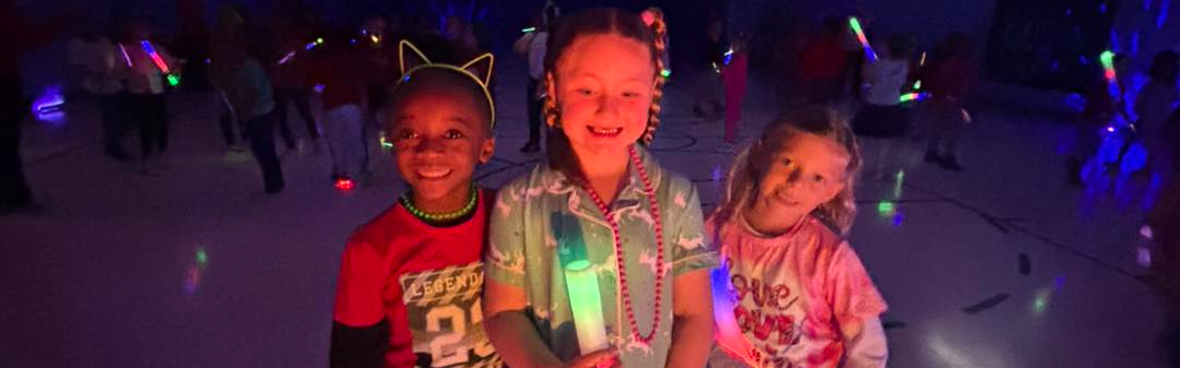A photo of students smiling and holding a big glow stick. 